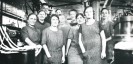 Foto: eine Schwarz-Weiss Fotografie, die mehrere Arbeiterinnen in der Baumwollspinnerei zeigt.
