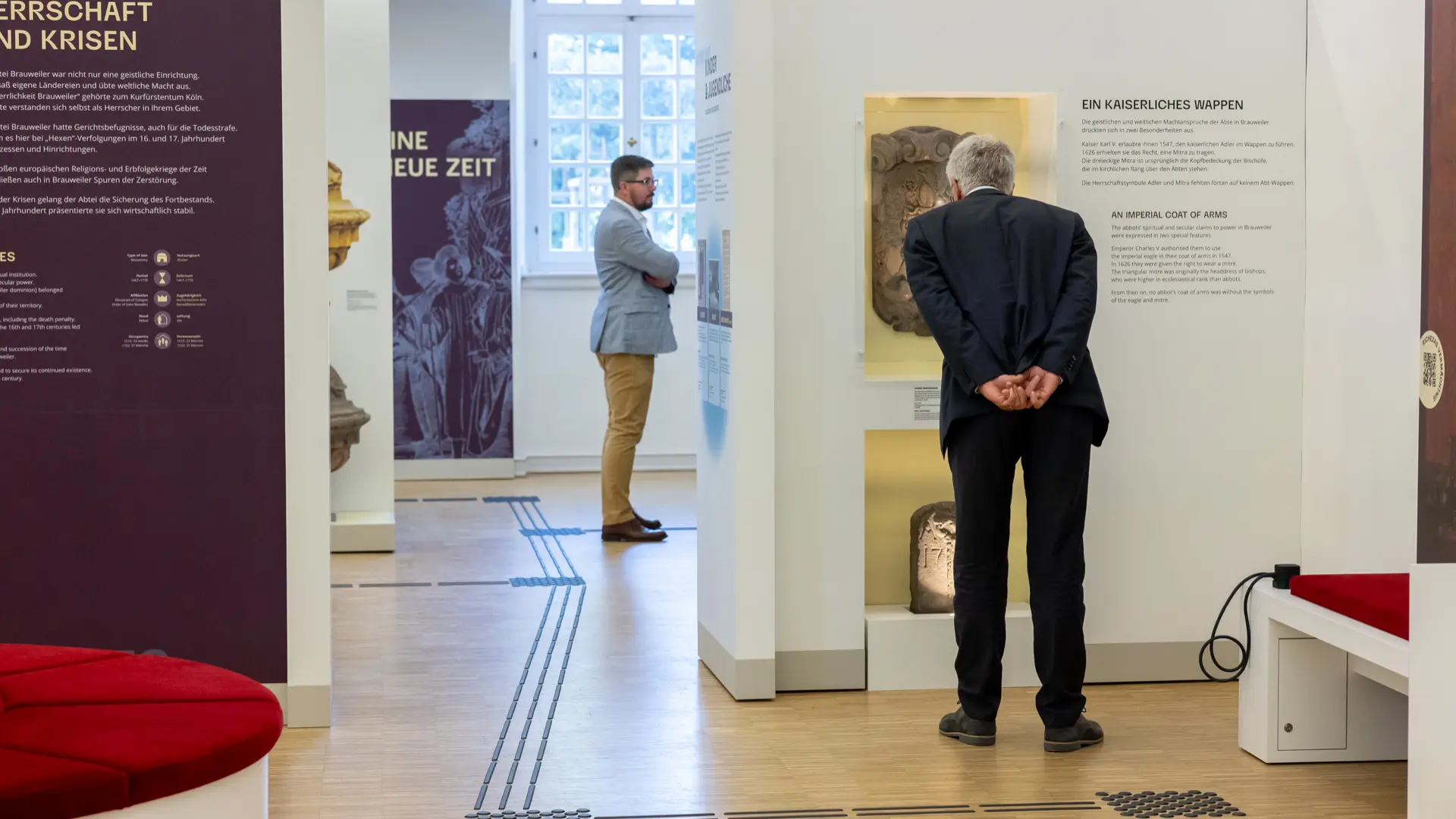 Foto von einer Ausstellung mit zwei Männern, die die Ausstellung betrachten