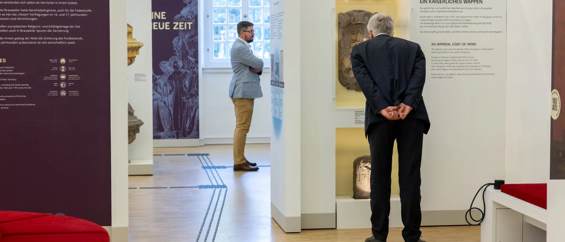 Foto von einer Ausstellung mit zwei Männern, die die Ausstellung betrachten