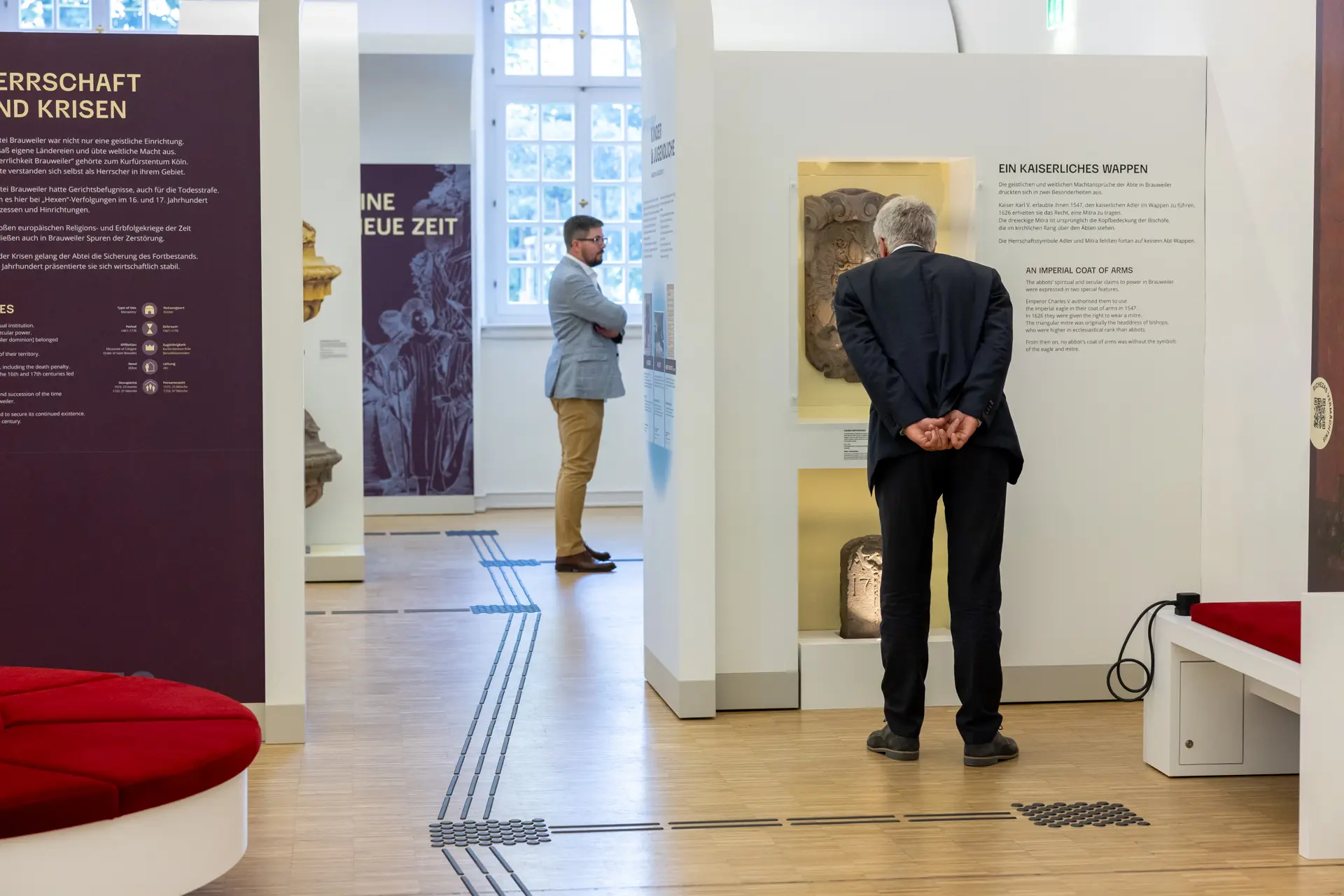 Foto von zwei Männern vor den Wänden der Dauerausstellung