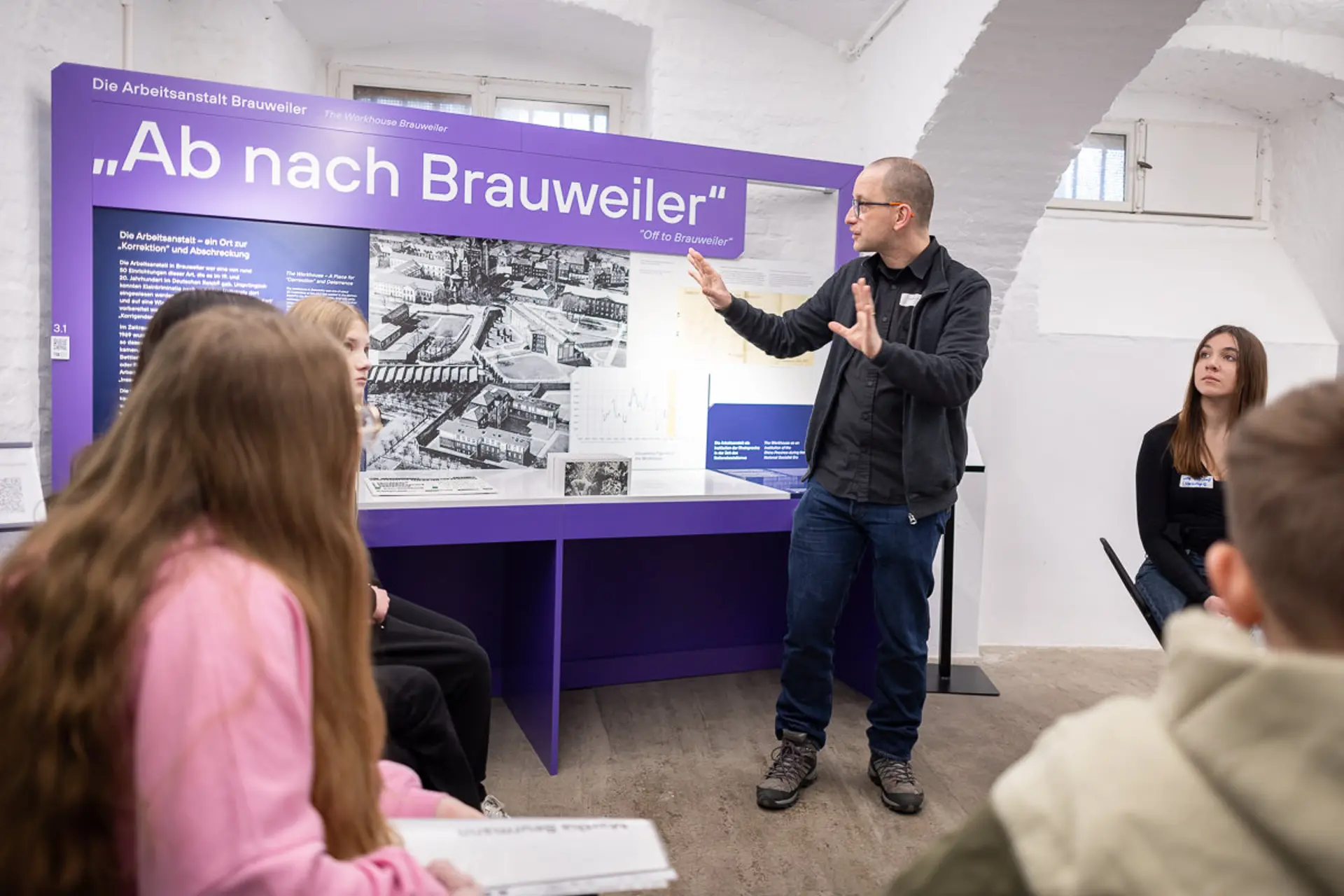 Foto von Guide in der Gedenkstätte vor einer Schautafel