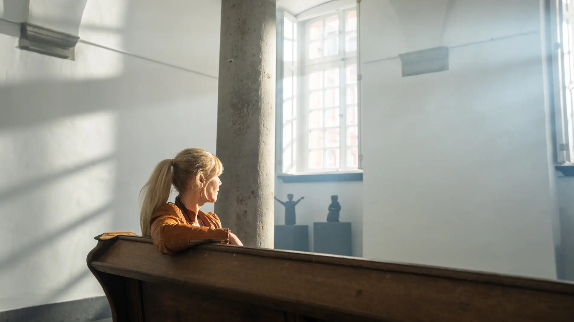 Foto von Frau auf Kirchenbank in Gewölbesaal