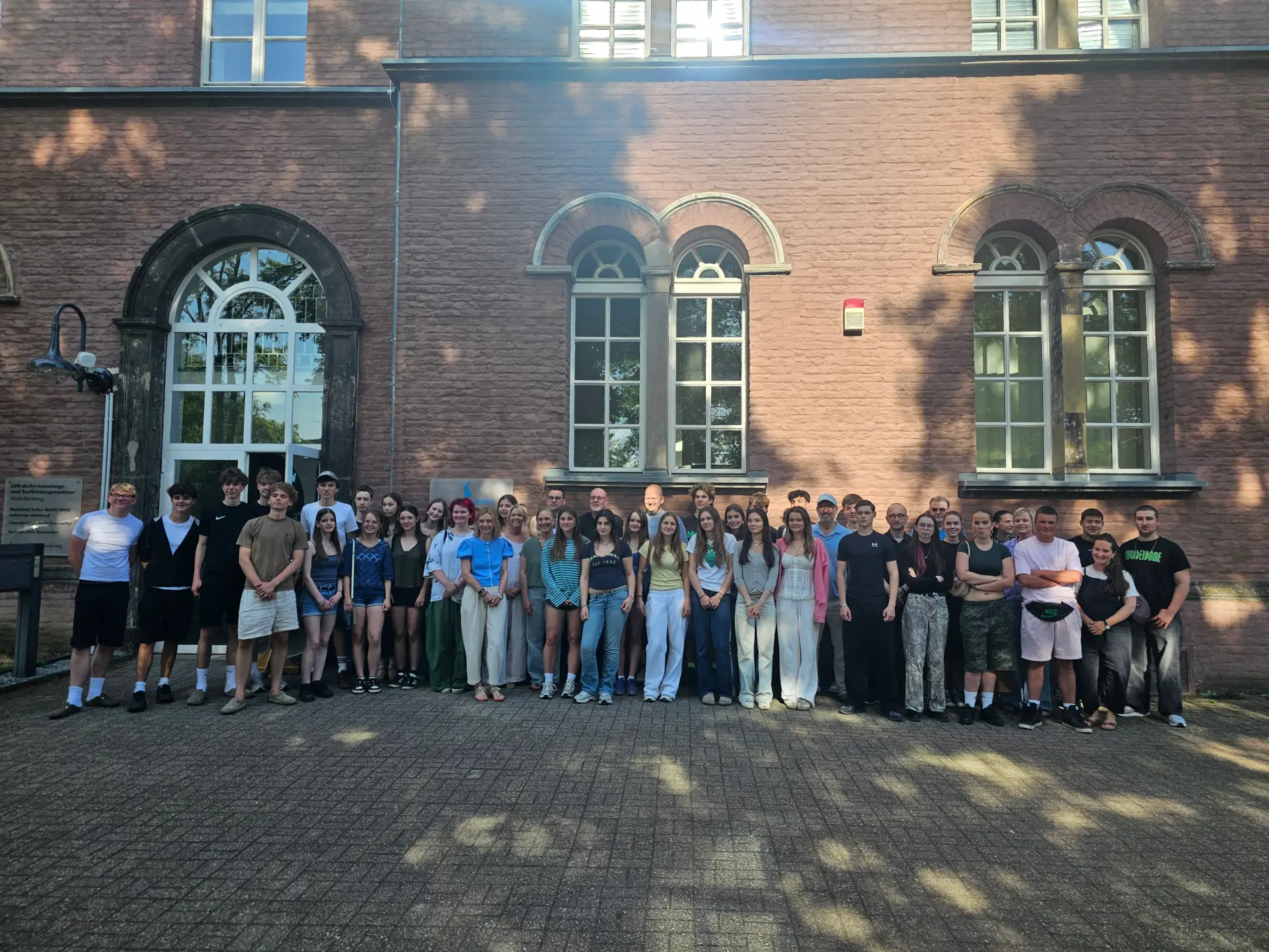 Foto von Schüler*innen und Lehrer*innen vor dem ehemaligen Frauenhaus