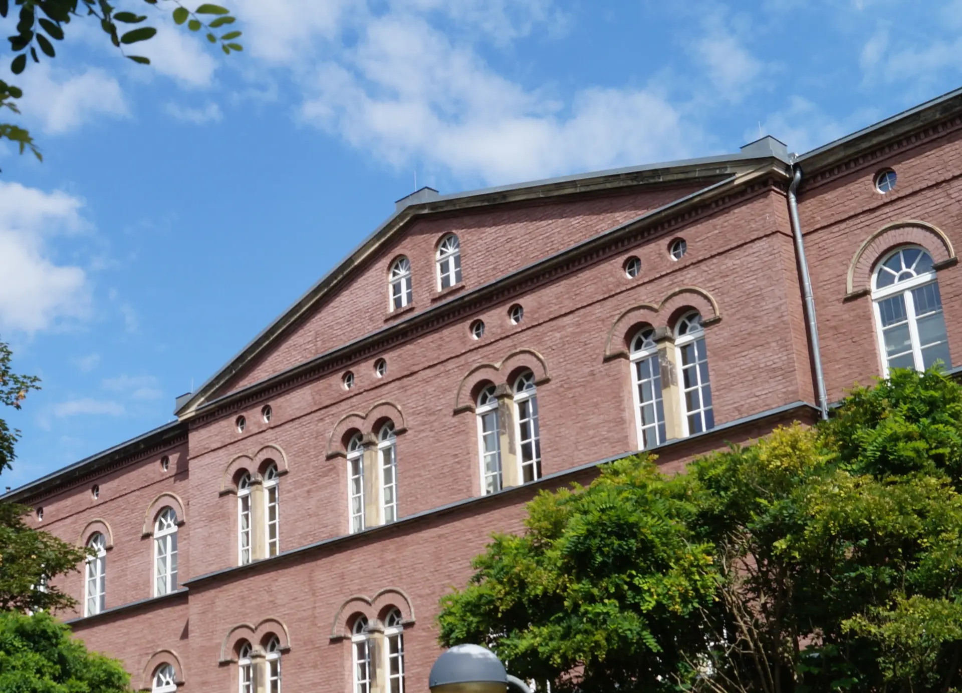 Foto eines Backsteingebäudes mit gebogenen weißen Fenstern