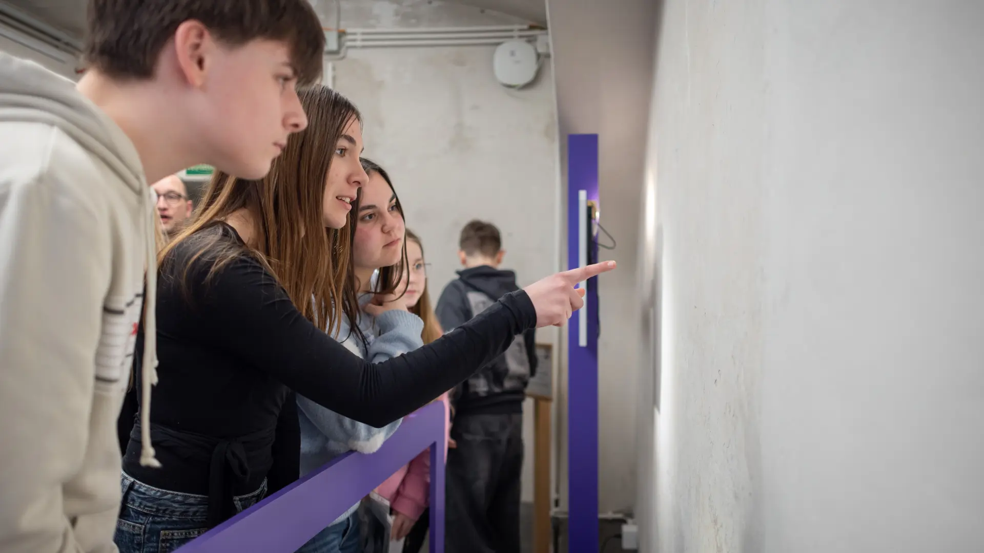 Foto von einer Schülerin, die auf eine Wand in der Gedenkstätte zeigt