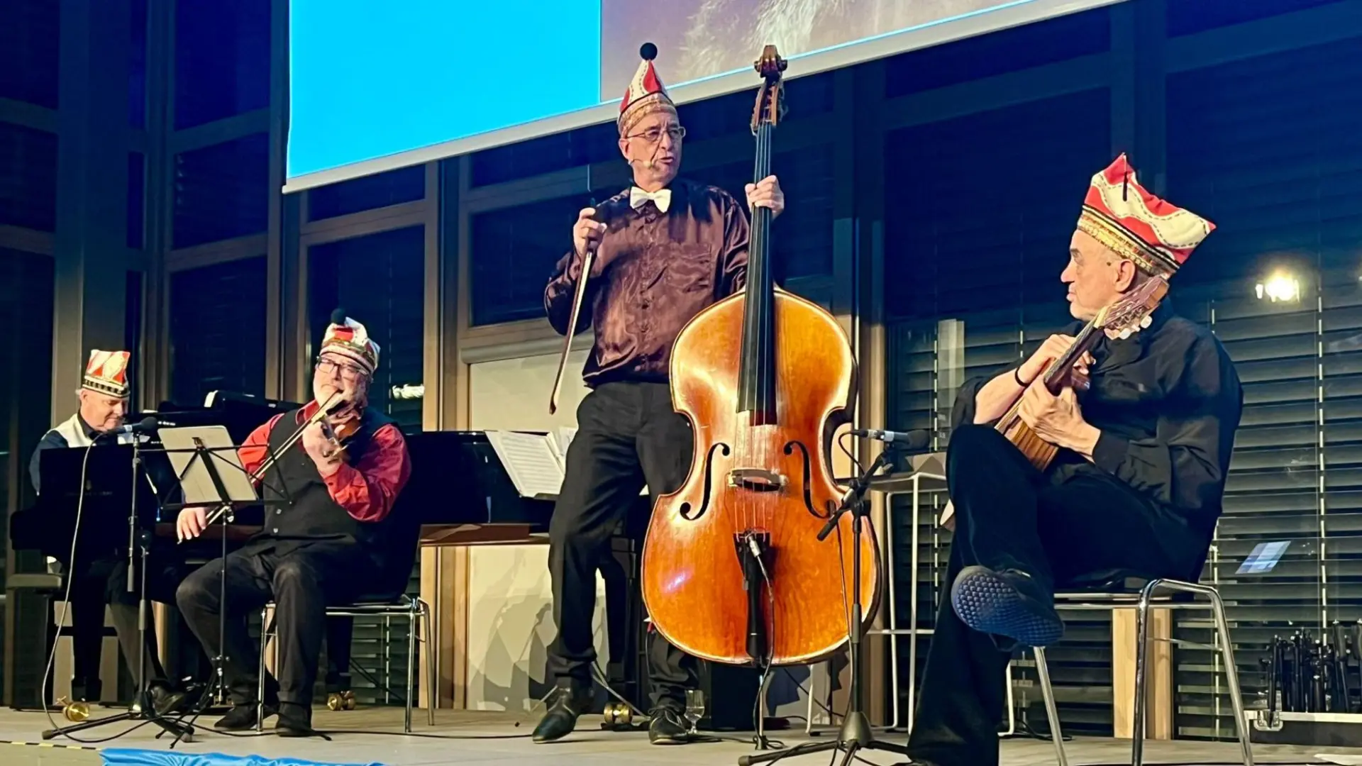 Foto von vier Musikern mit Karnevalsmützen