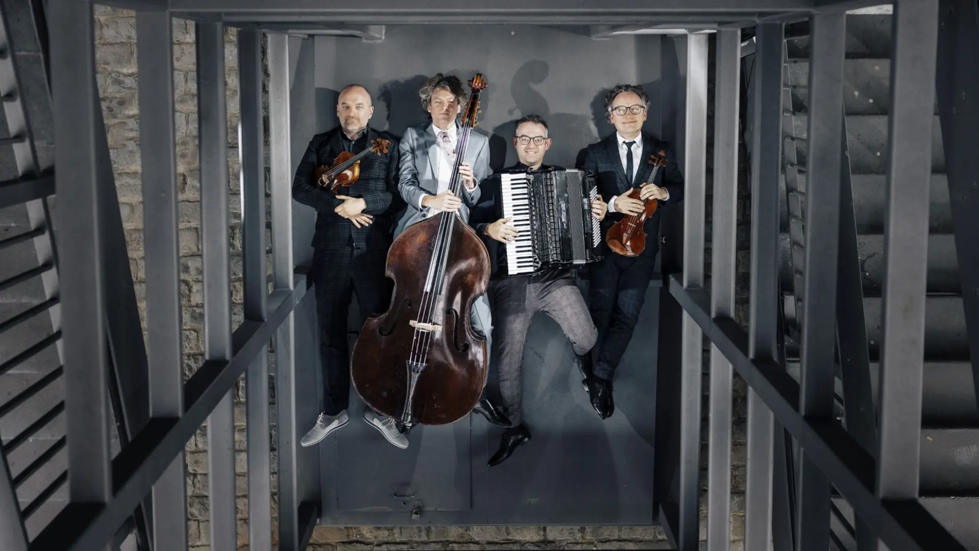 Foto von vier Personen mit Instrumenten liegend