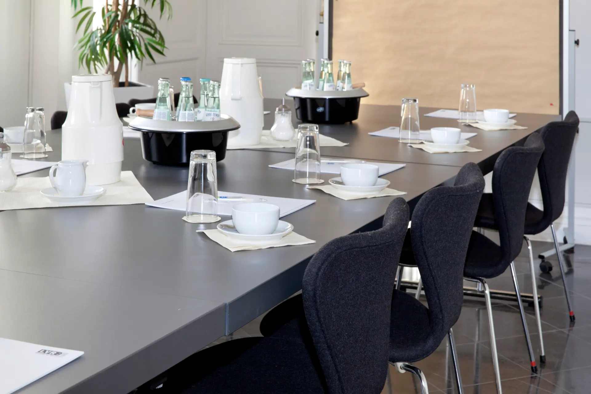 Foto von eingedeckten Tisch und einer Pinnwand im Hintergrund