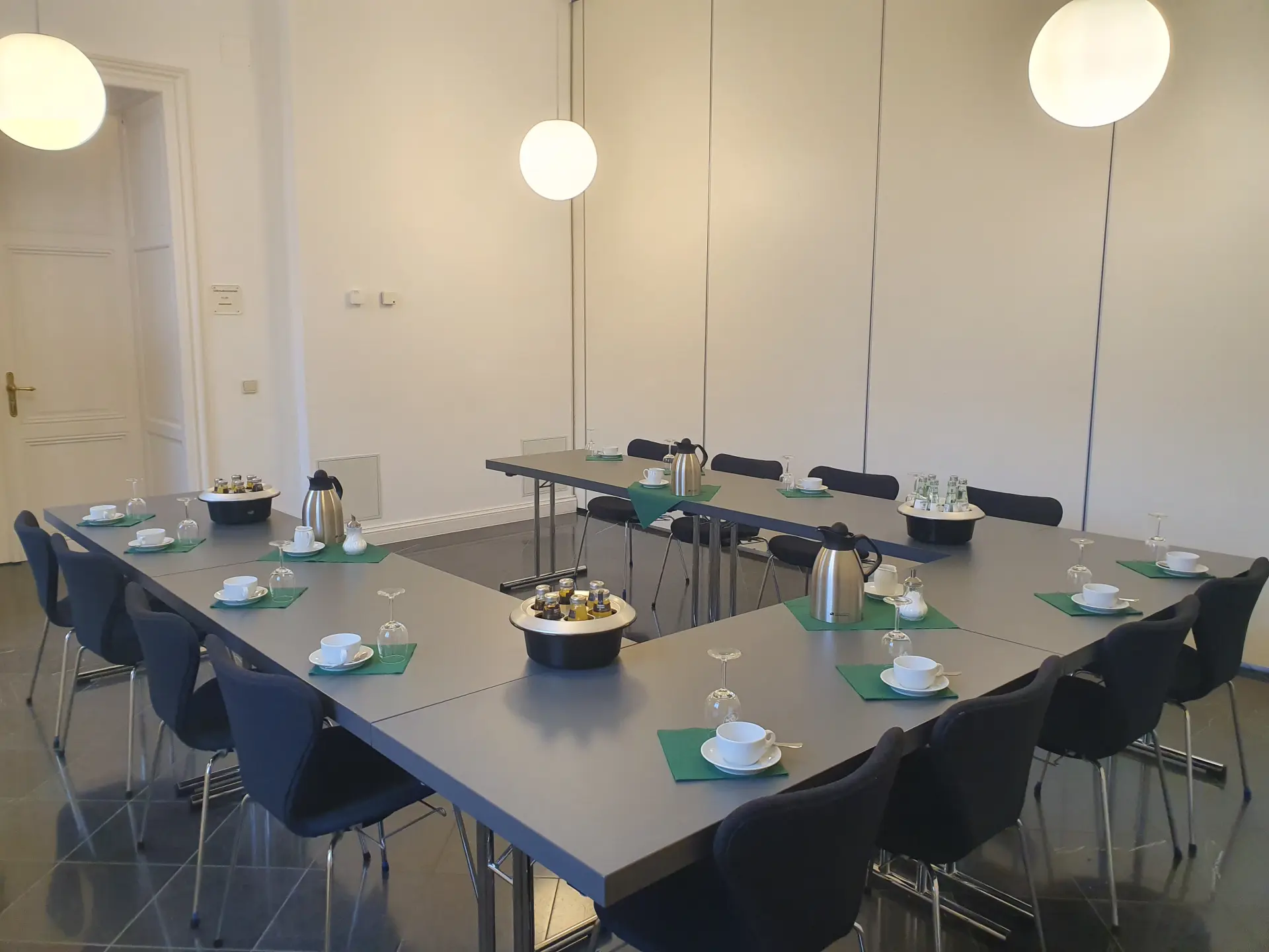 Foto von Tischen in U-Form mit Kaffeetassen