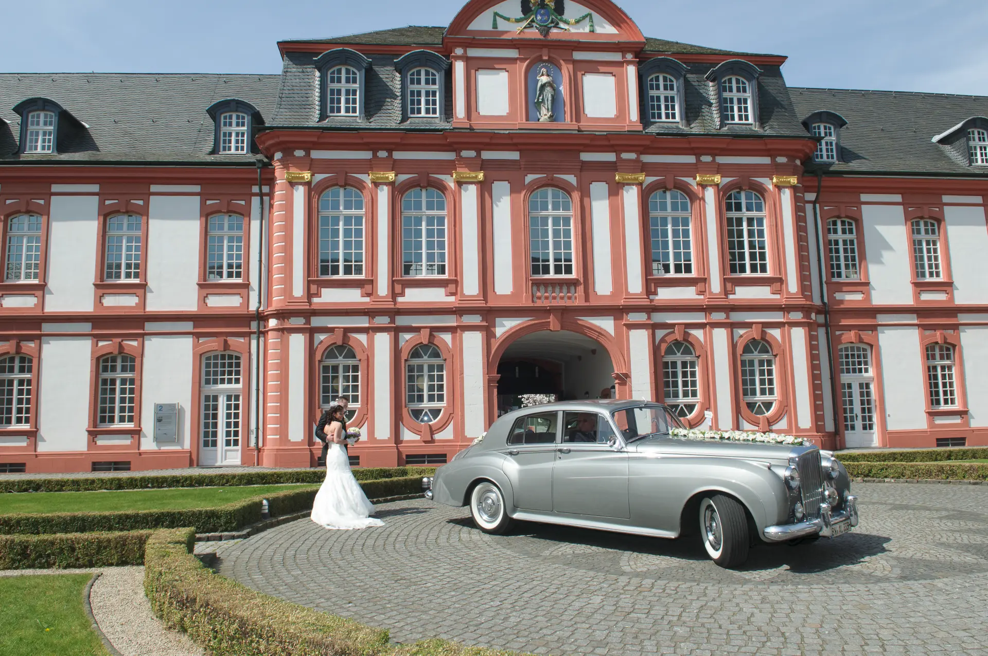 Foto von historischem Oldtimer und Brautpaar vor der Prälatur
