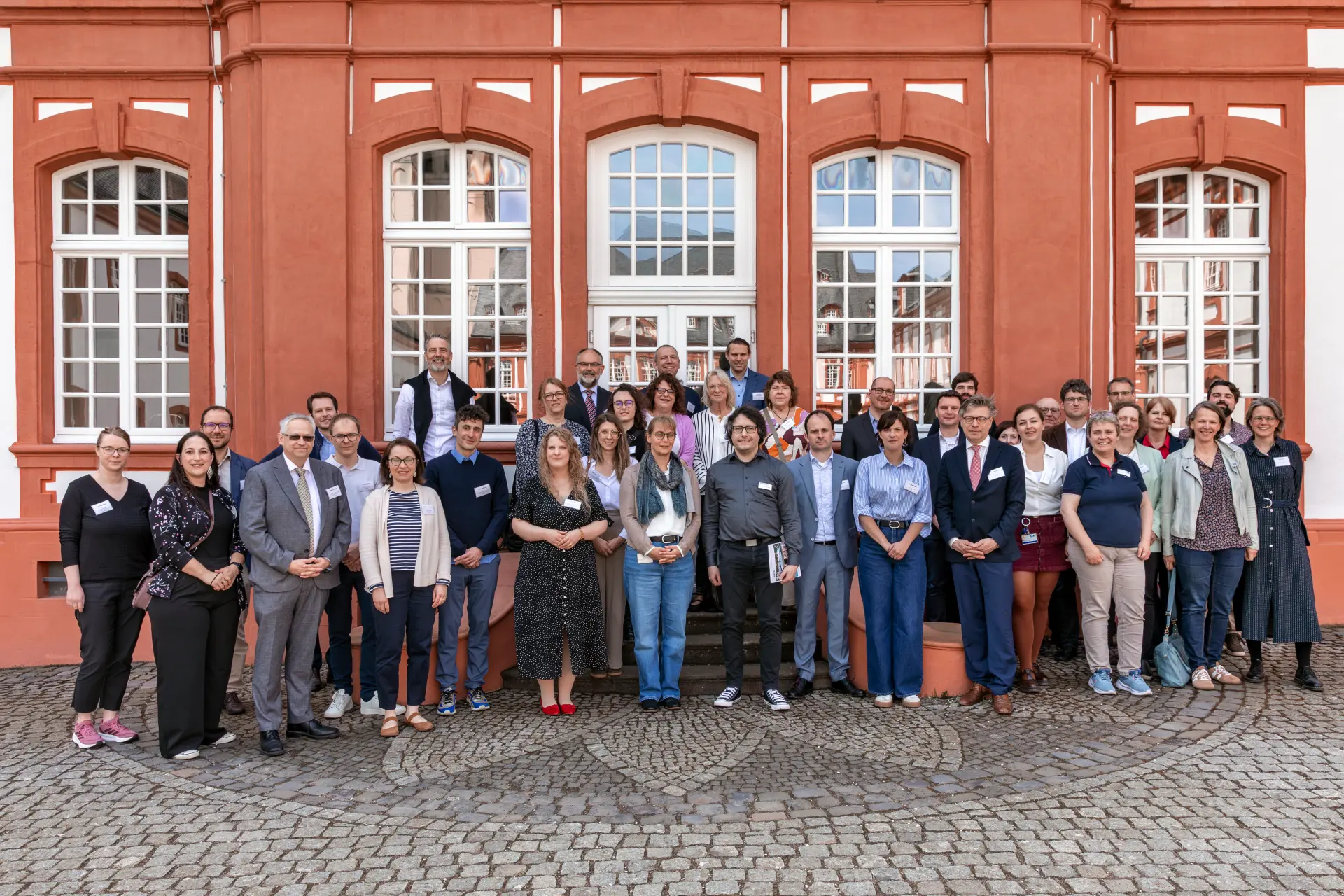 Foto der Teilnehmendengruppe des Internationalen Archivsymposiums 2026 im Innenhof der Abtei Brauweiler.