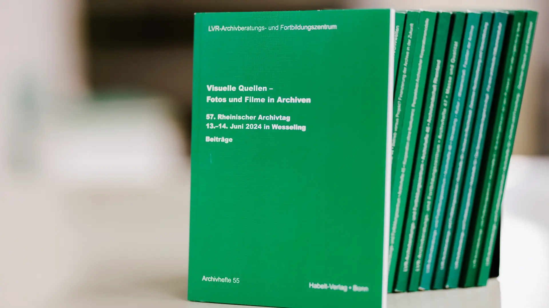 Mehrere dünne grüne Bücher nebeneinander