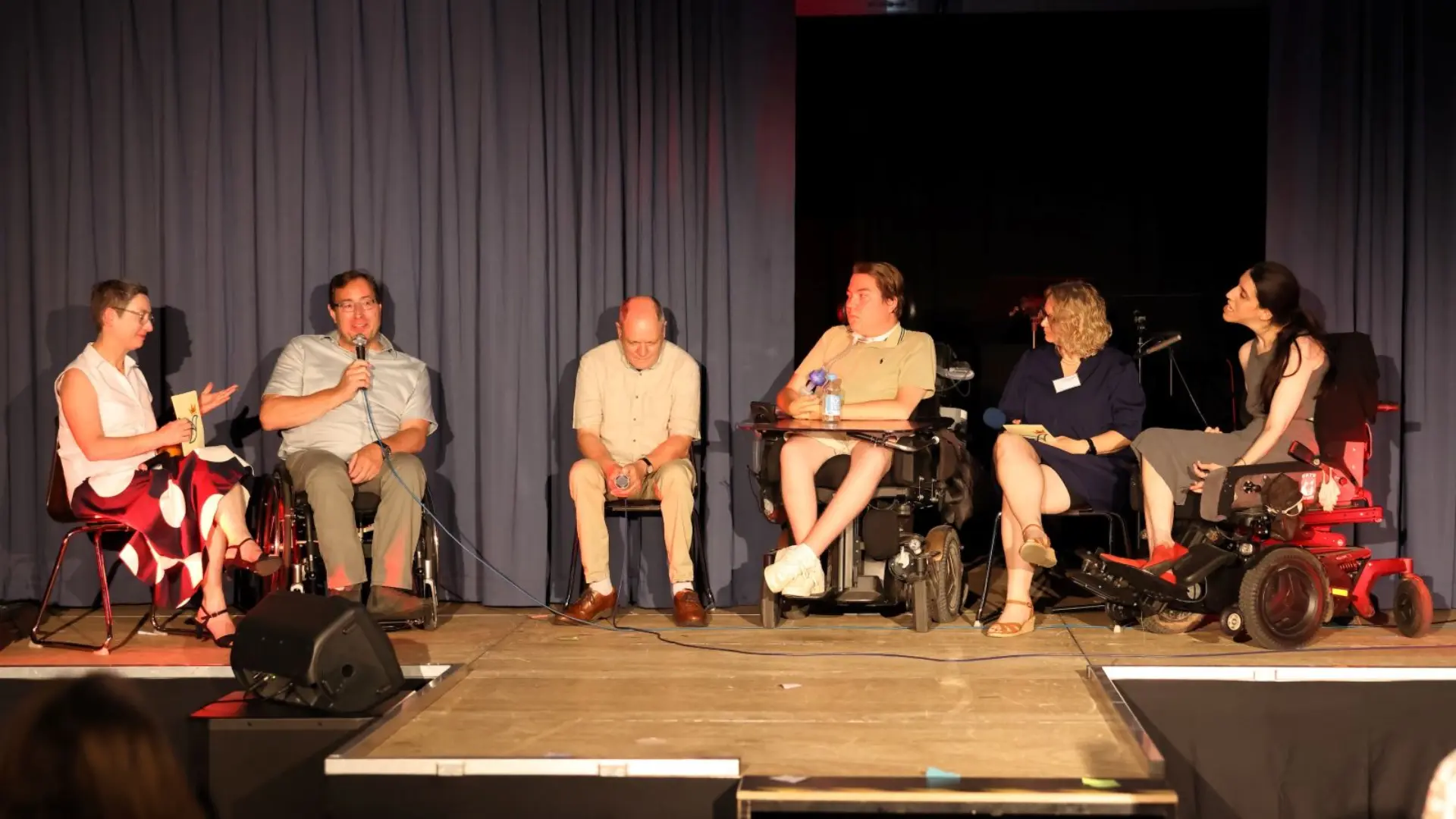 Ehemalige Schüler auf der Bühne bei einer Podiumsdiskussion