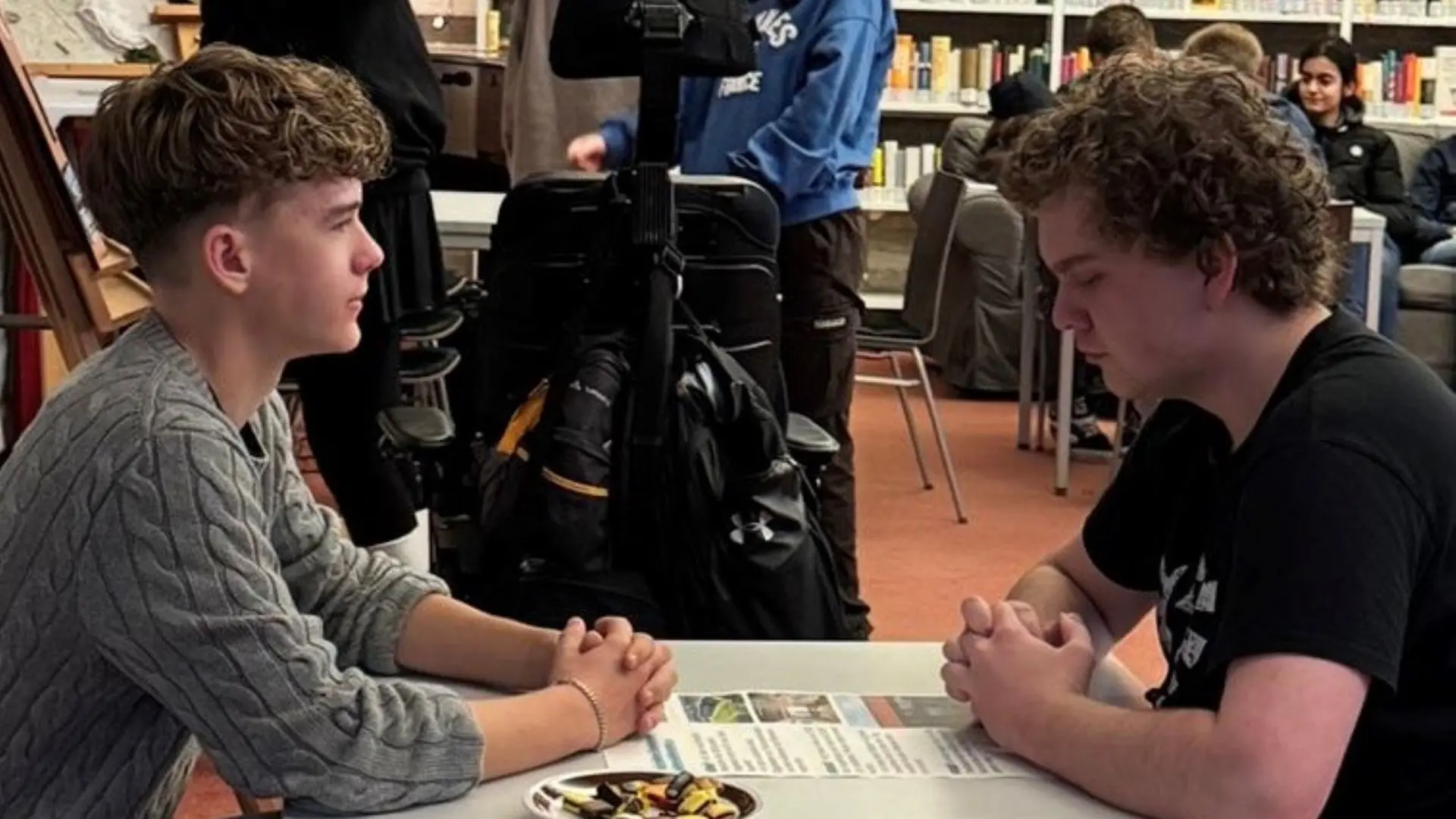 Zwei Schüler*innen sitzen beim Praktikumsfest an einem Tisch und reden miteinander
