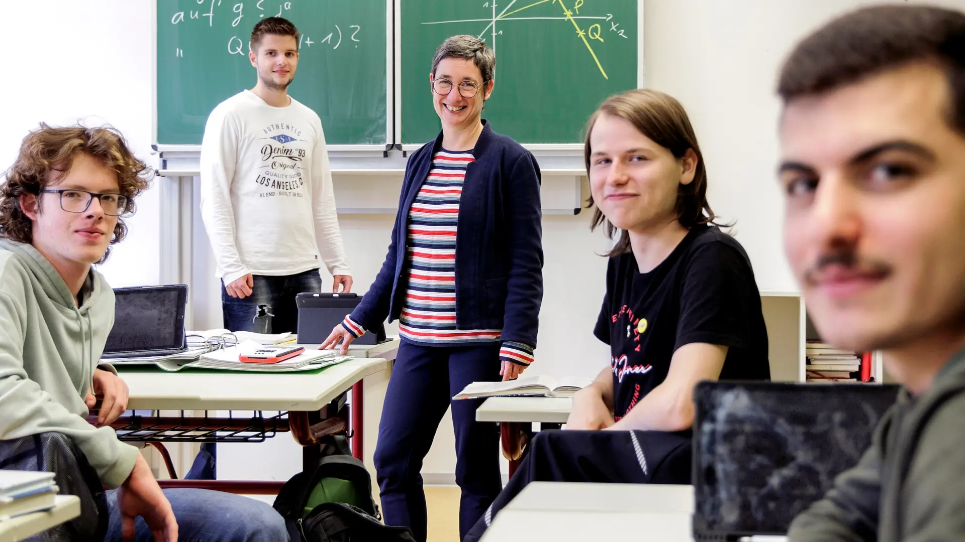Lehrerin mit Schüler*innen vom Mathe-Leistungskurs im Klassenzimmer