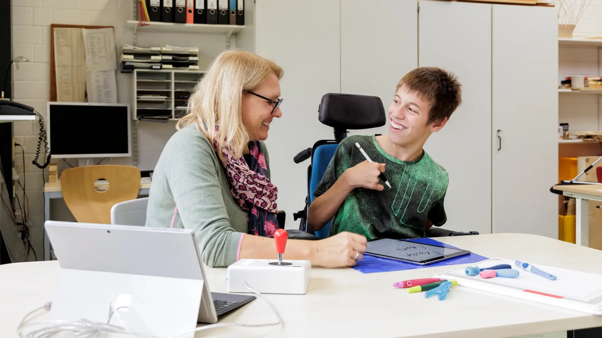 Ergotherapeutin mit Schüler bei der Therapie