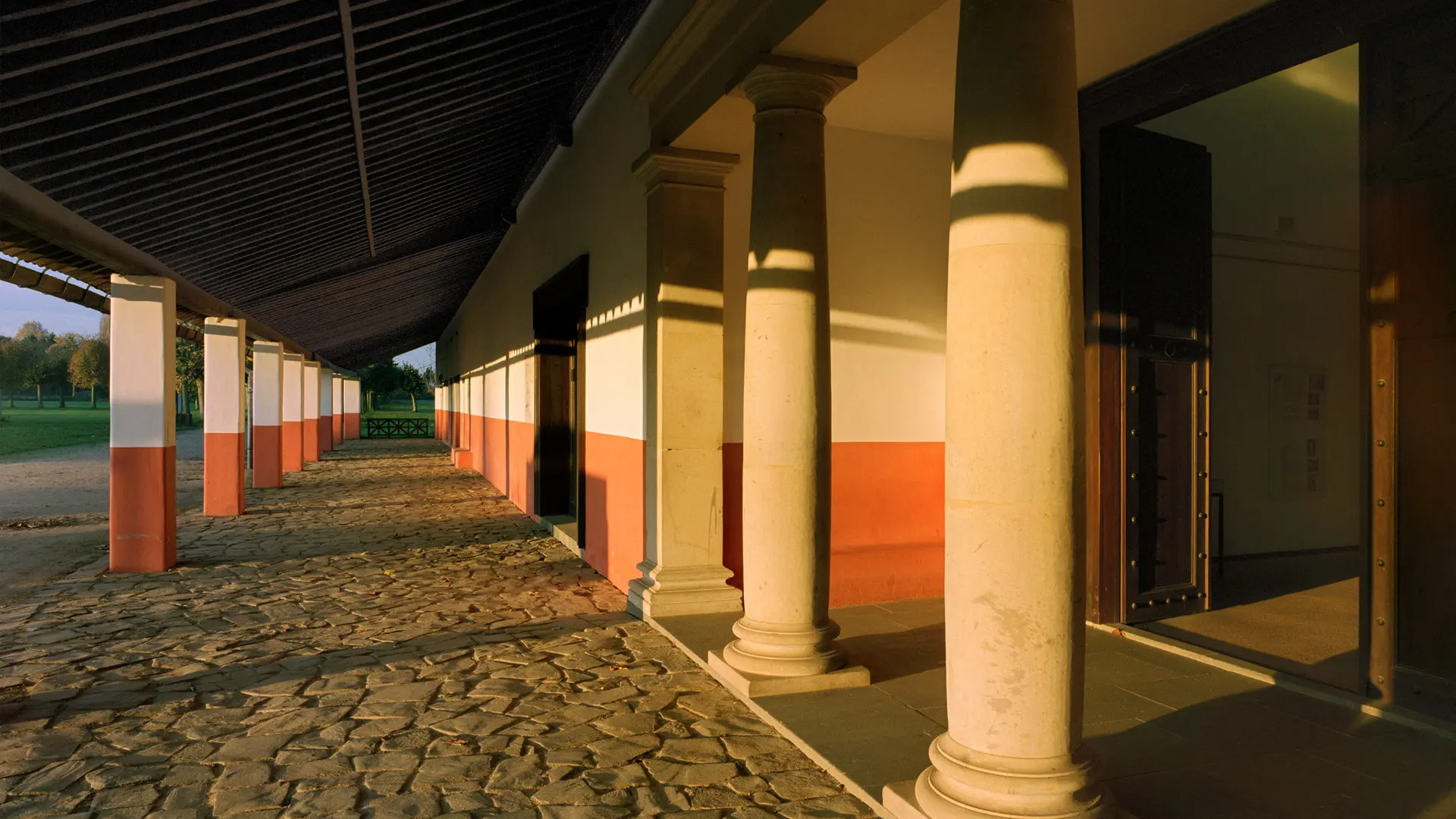 Blick entlang der Porticus der römischen Herberge im orangegelben Morgenlicht