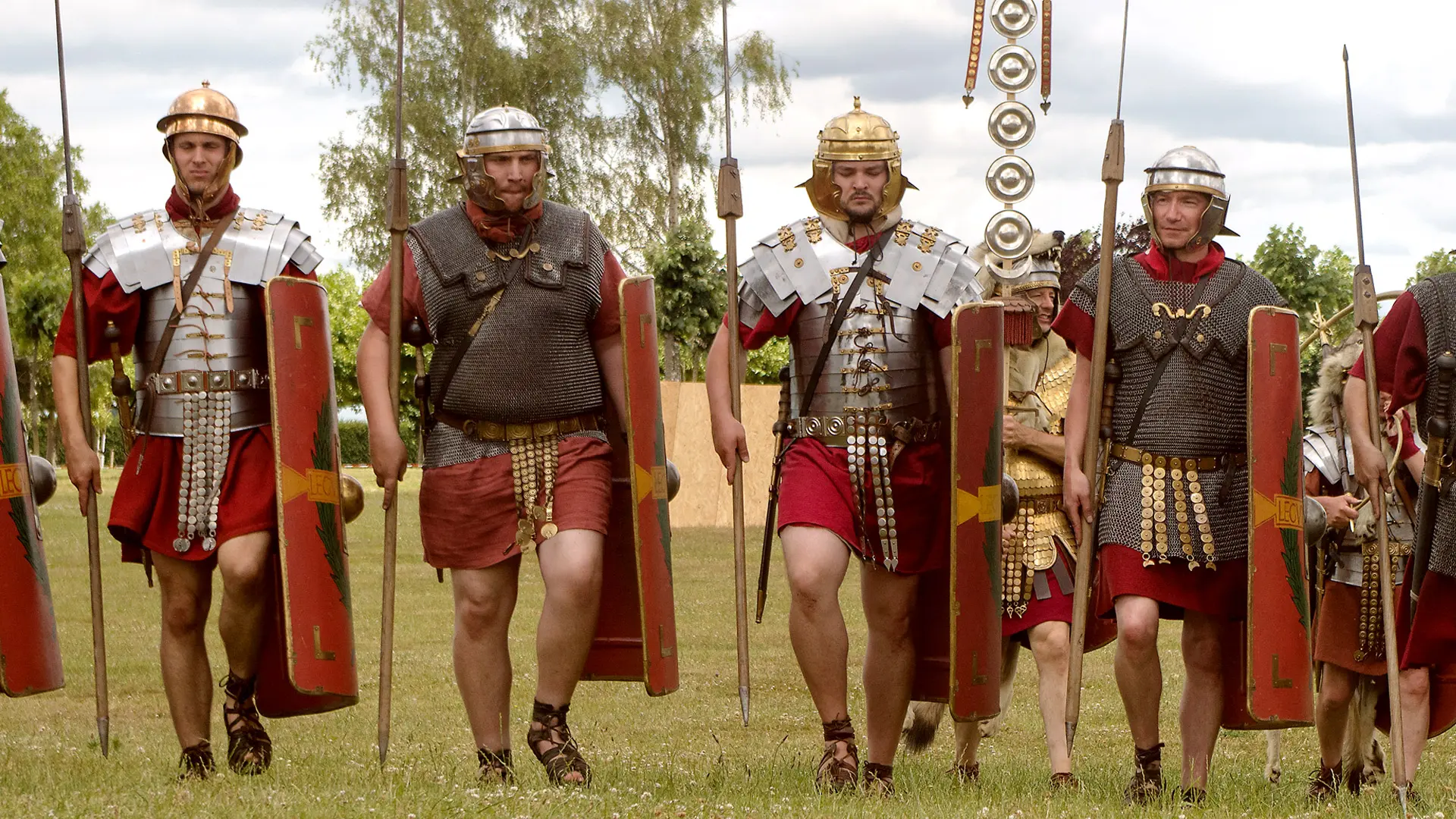 Gruppe von römischen Reenactor-Legionäre läuft in breiter Linie auf den Betrachter zu