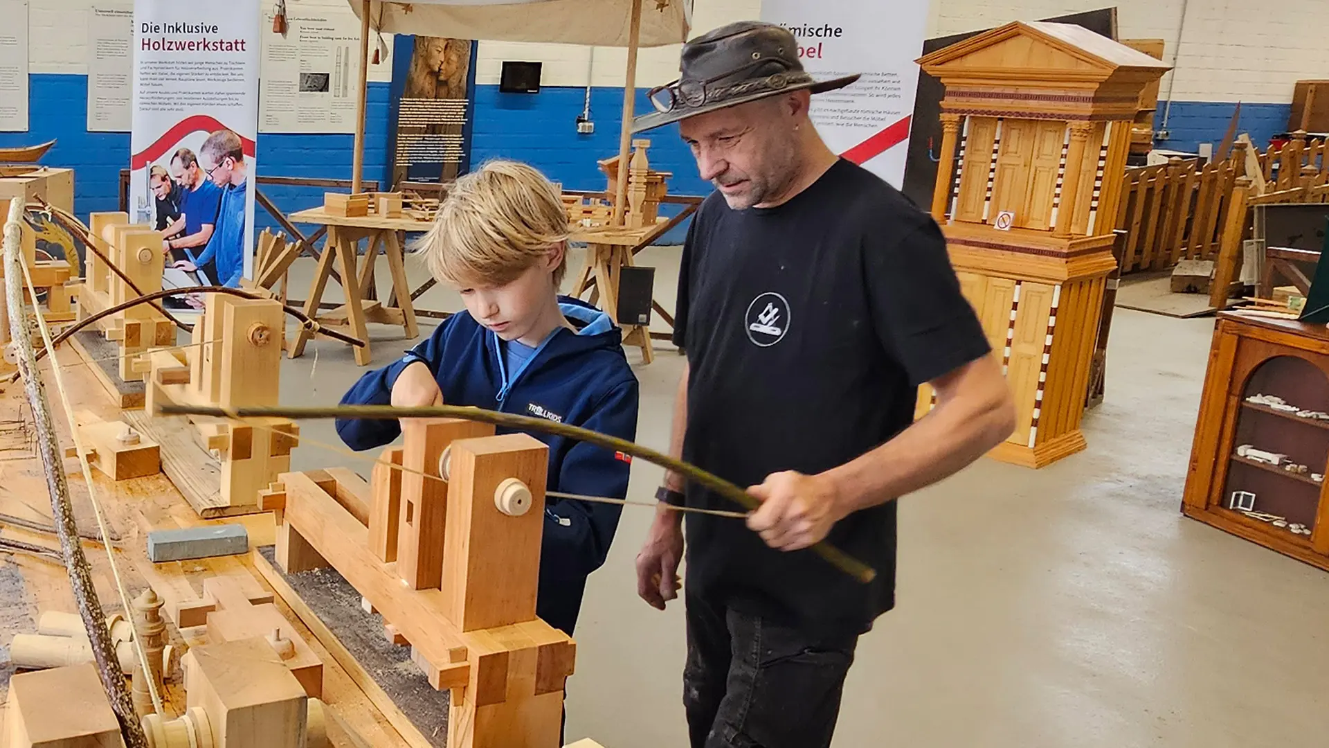 Kind und Schreiner beim Drechseln in der Holzwerkstatt