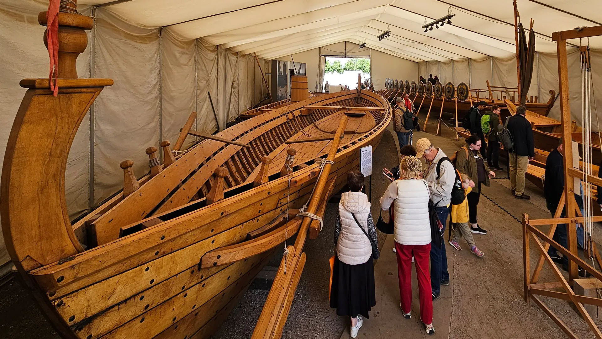Blick in die Schiffshalle mit mehreren großen und kleinen Holzschiffen und vielen Besuchern