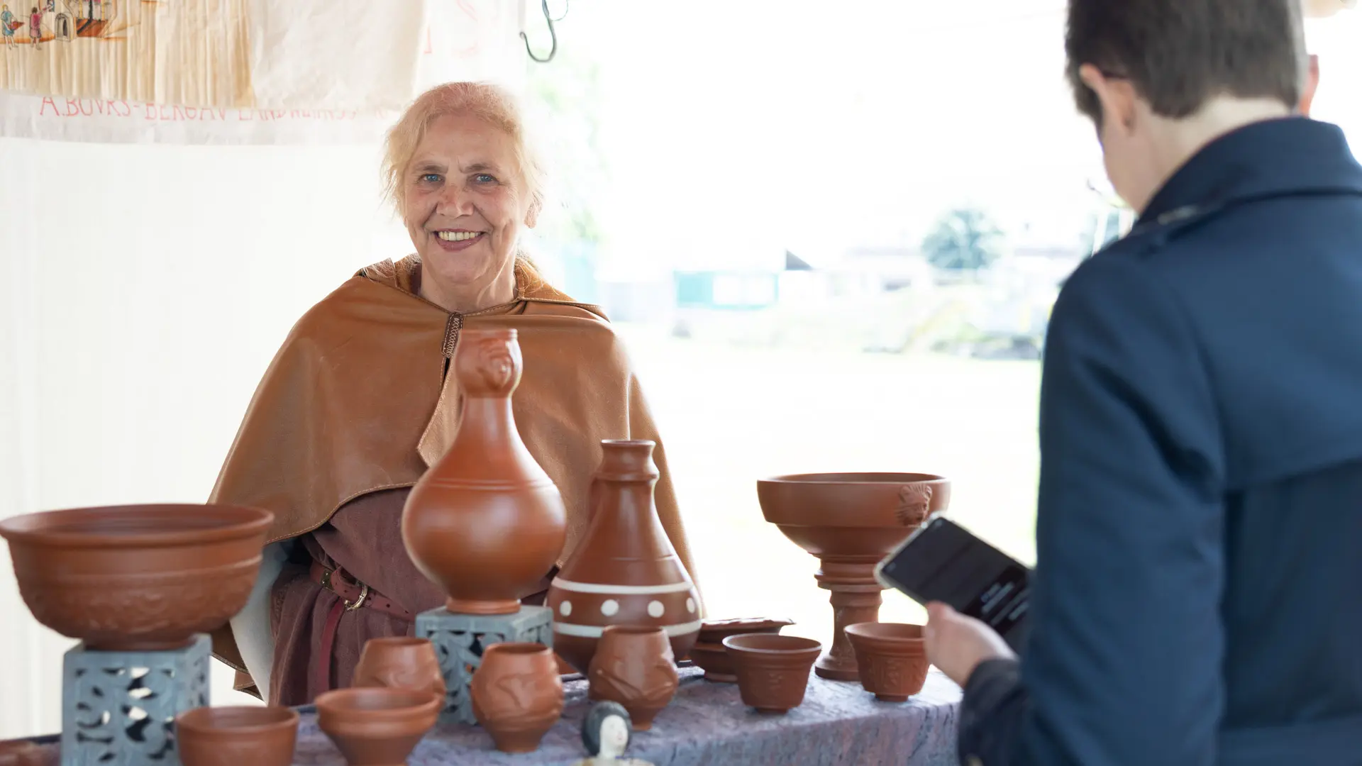 Töpferstand auf dem Limesfest mit Töpferin und Käufer