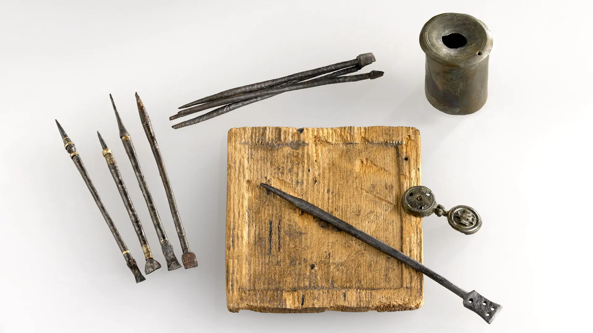 Antikes Schreibset aus einem Fund in der Stadt, mehrere Griffel, Feder, ein Tintenfass, zentral eine quadratische Wachstafel (Originale)