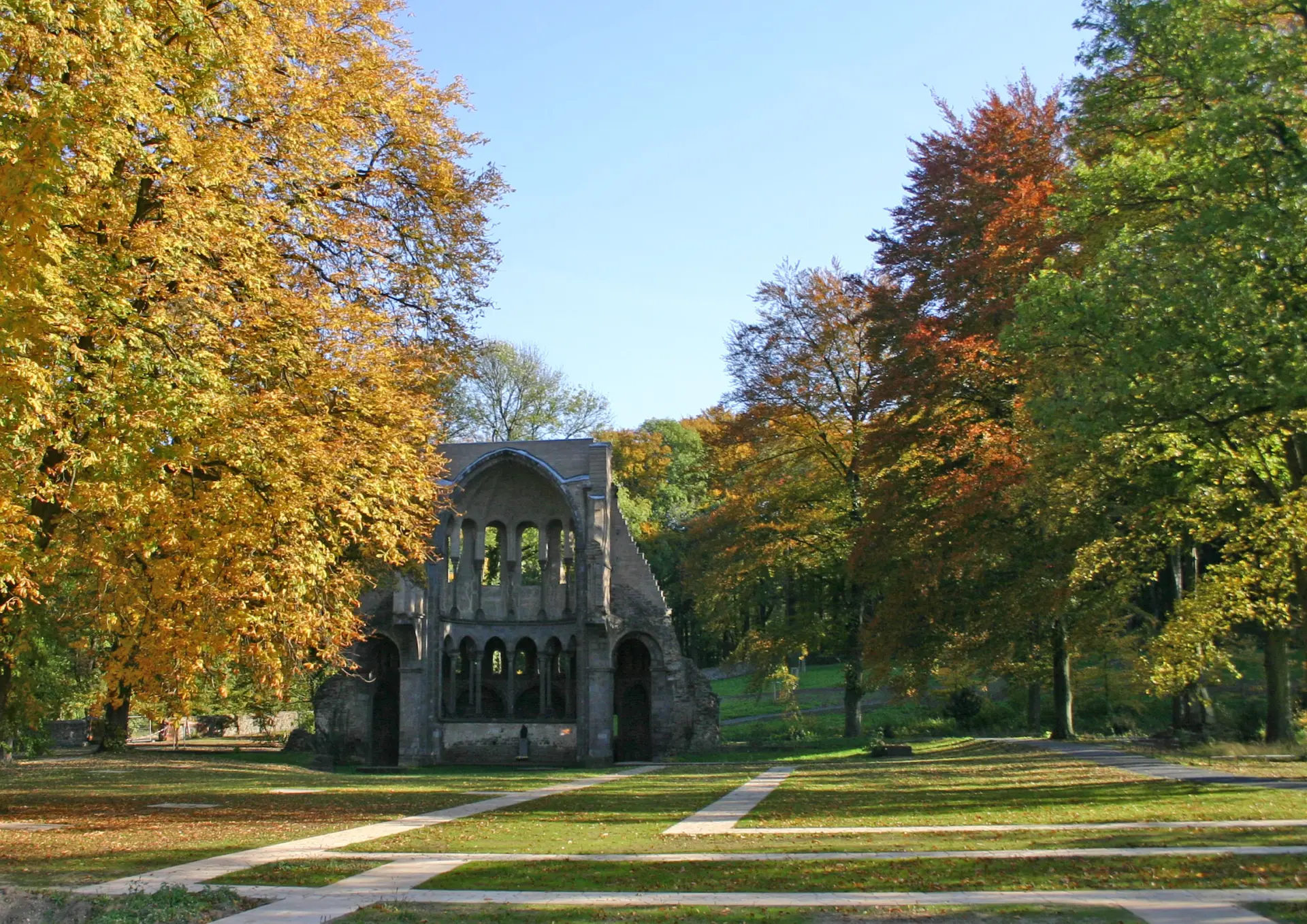 Ansicht der Klosterruine umgeben von Bäumen mit bunten Blättern.