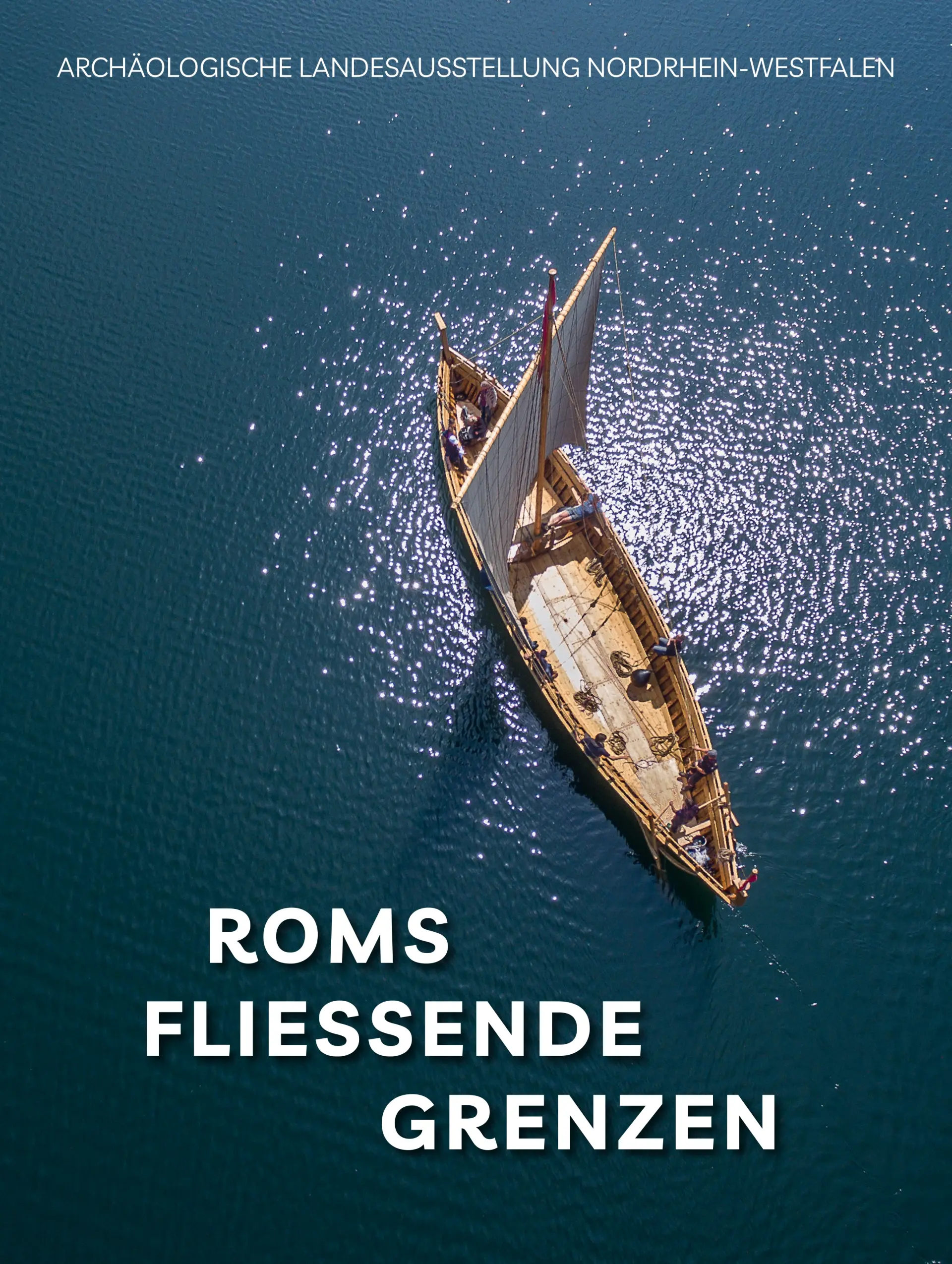 Buchtitel wo oben „Archäologische Landesausstellung Nordrhein-Westfalen“ und unten der Titel „Roms fliessende Grenzen“ steht. Aus der Vogelperspektive fährt ein historisches Holzsegelschiff mit aufgespannten Segeln über dunkelblaues, glitzerndes Wasser.