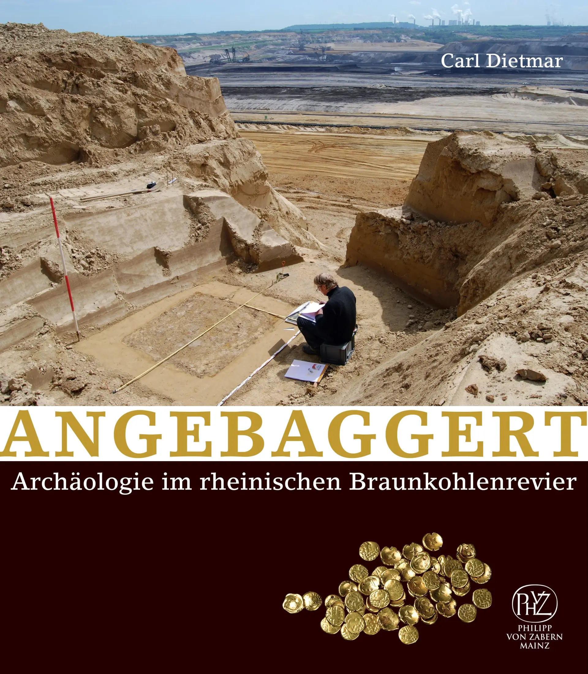 Das Cover "Angebaggert. Archäologie im rheinischen Braunkohlerevier" zeigt eine archäologische Ausgrabung in einem Braunkohle-Tagebau; im Vordergrund dokumentiert eine Person Befunde, im Hintergrund erstreckt sich die großflächige Tagebaulandschaft. Unten sind Goldmünzen abgebildet.