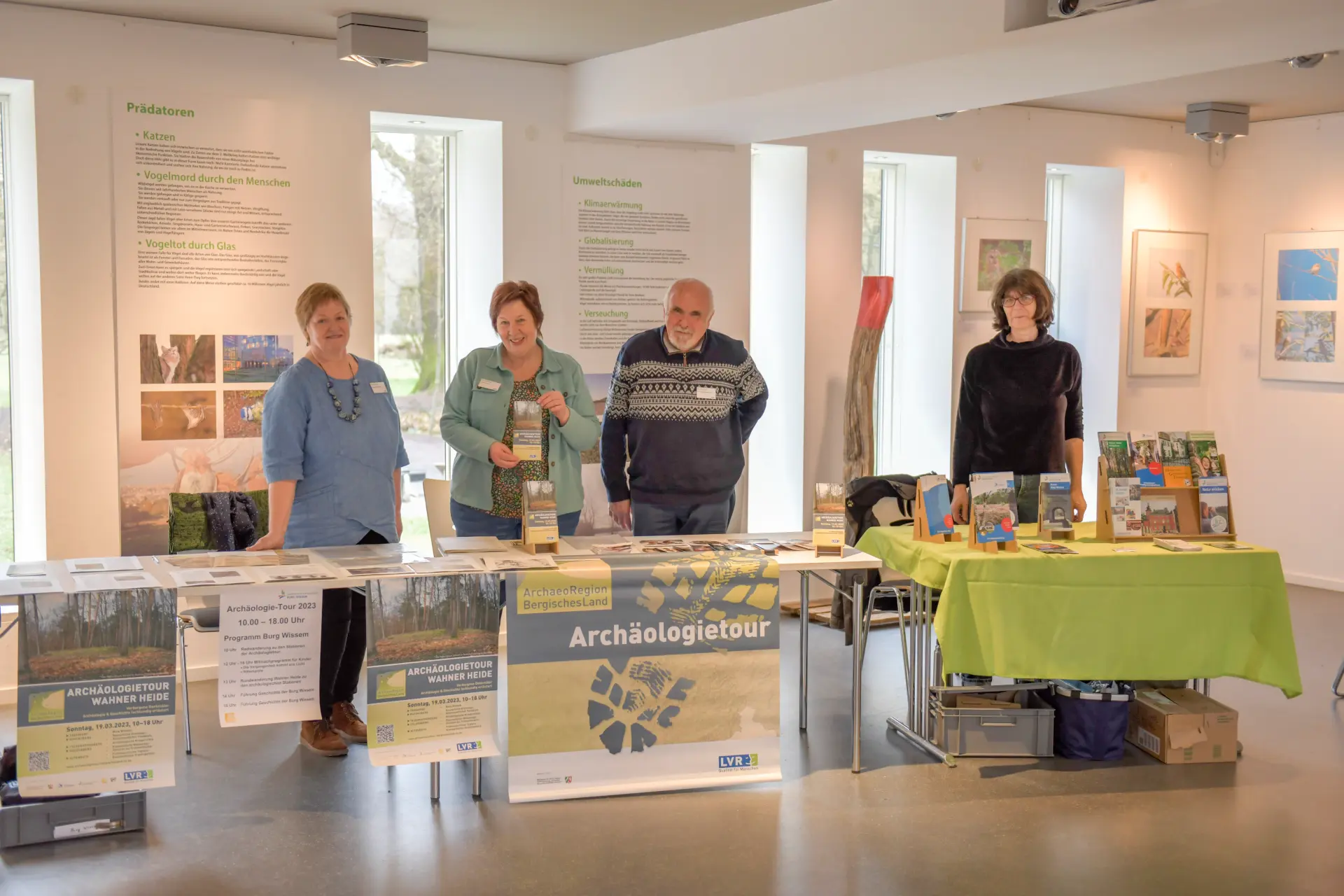 Vier Personen stehen an einem Informationsstand. Sie informieren über die Archäologietour Bergisches Land.