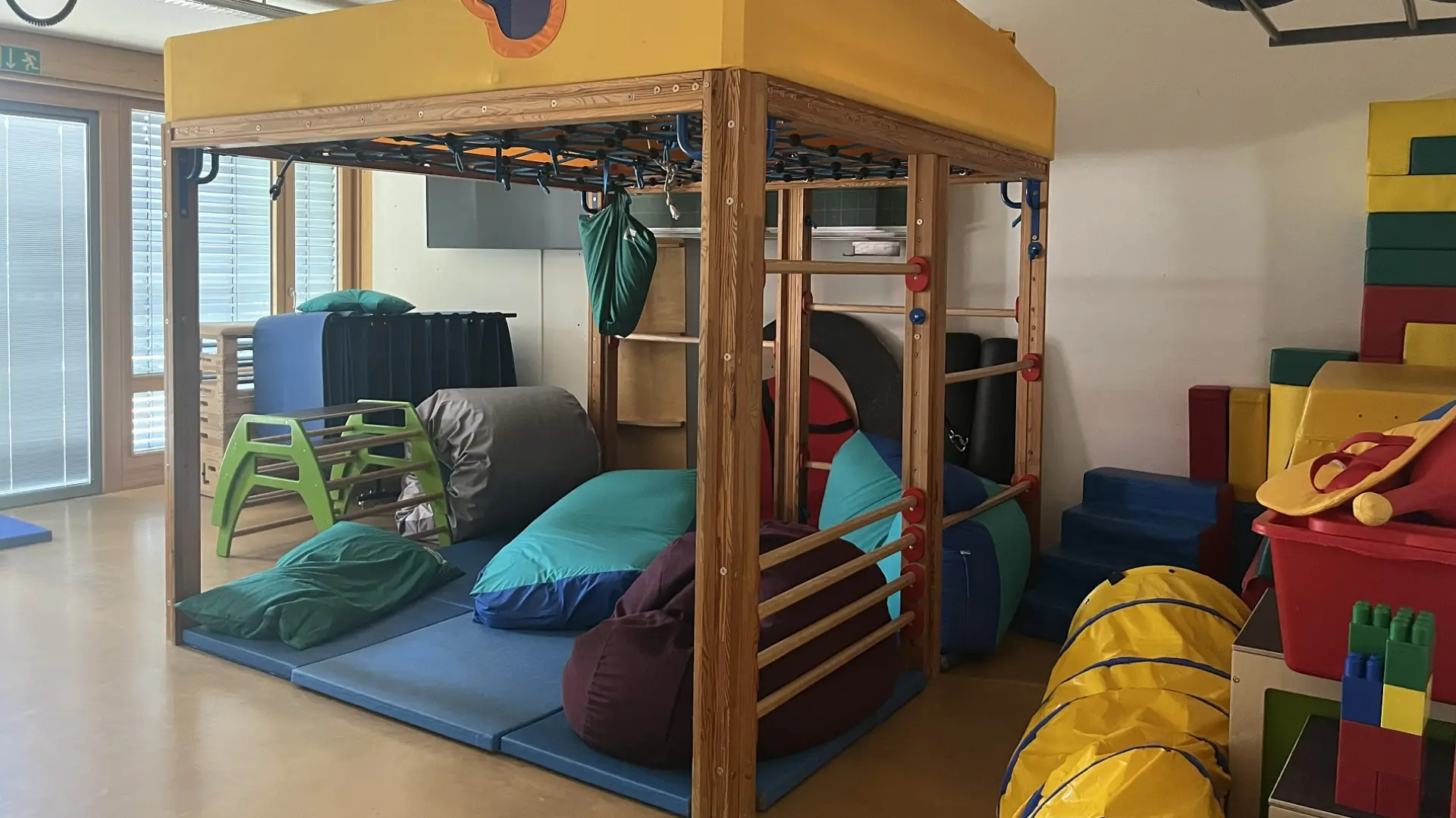 Klettergerüst mit Kissen und Matten im Psychomotorikraum einer Schule