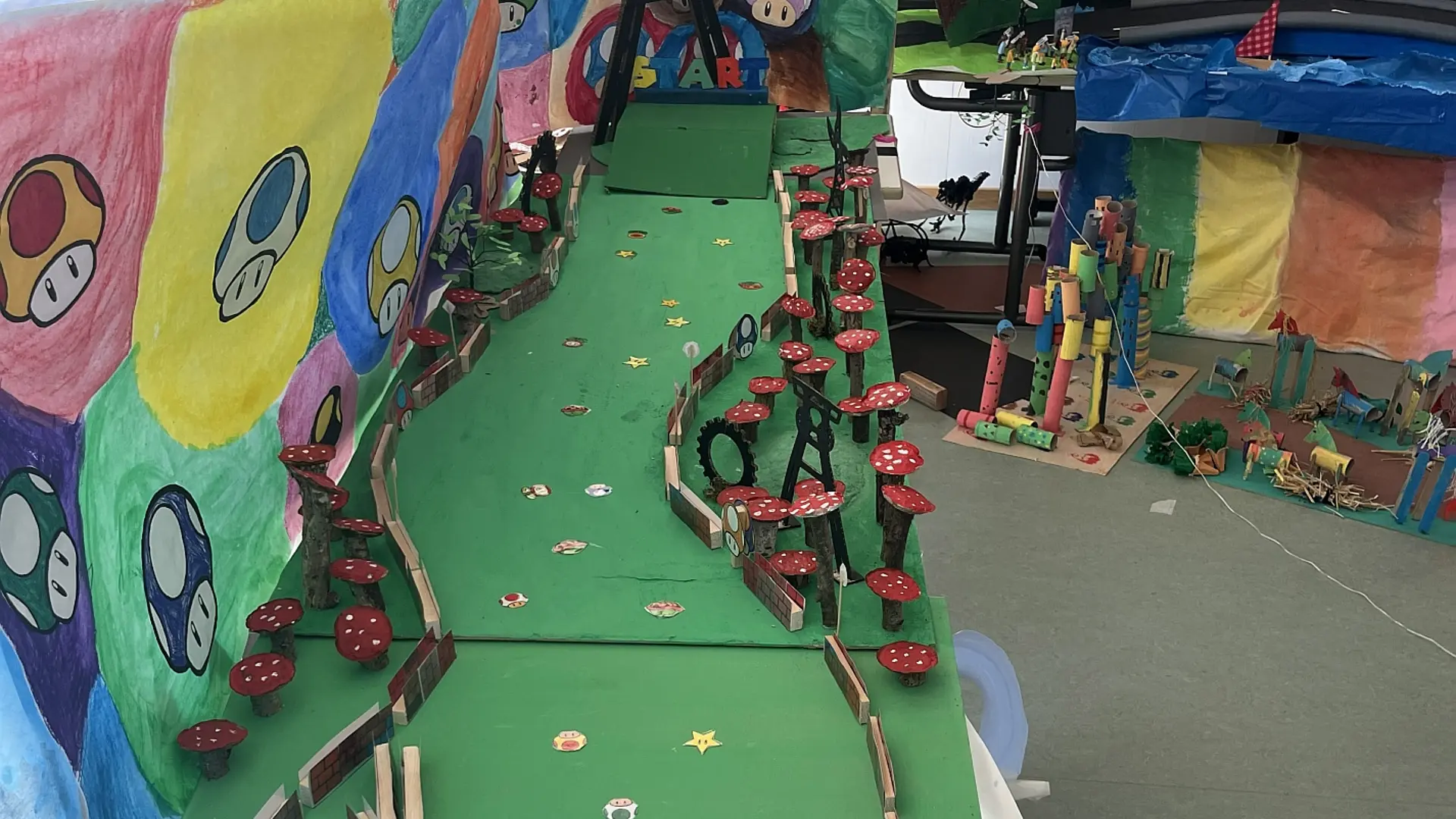 grünes Mario-Kart-Modell mit bunten Pilzen und Startrampe aus Pappe