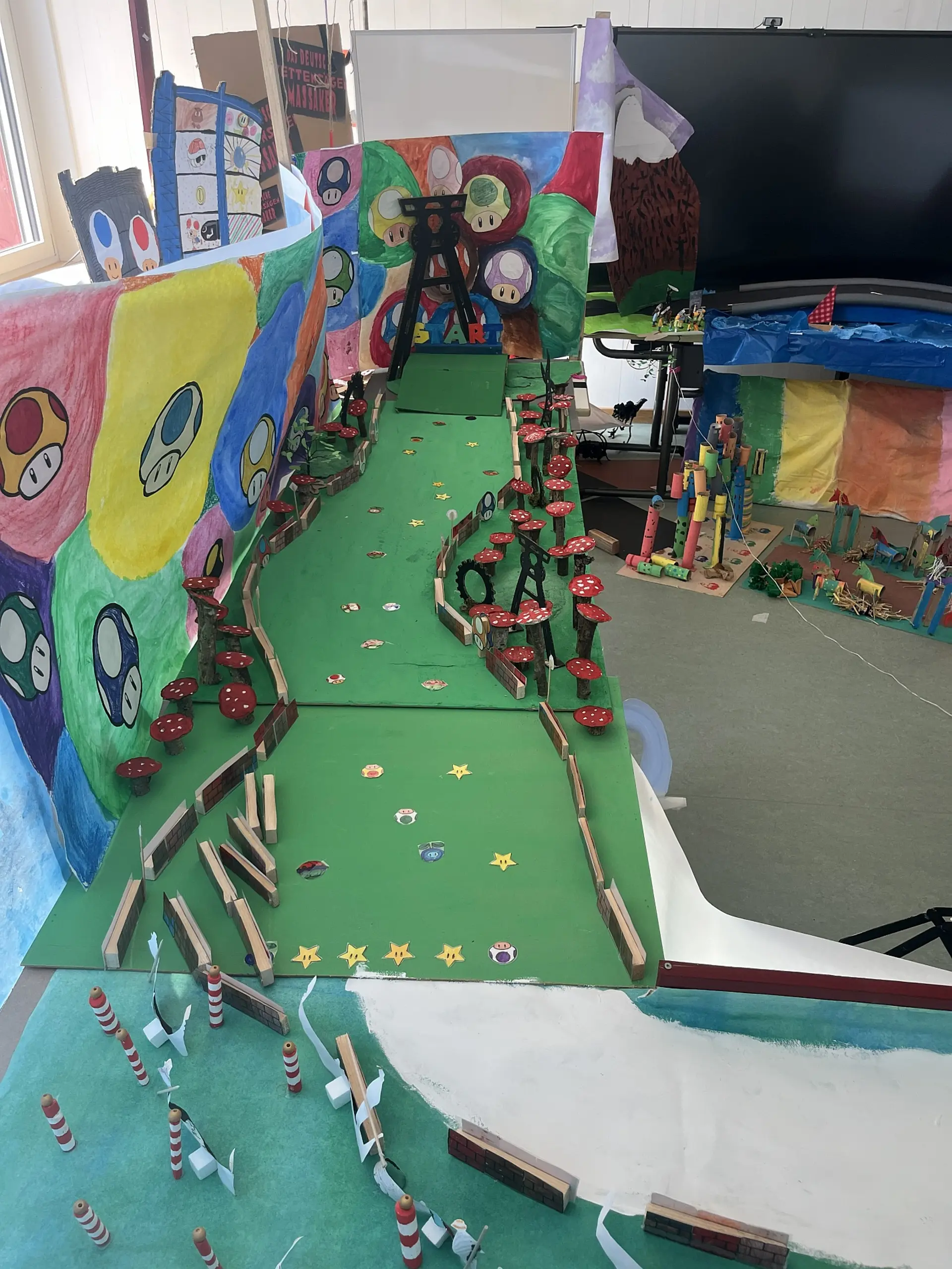 grünes Mario-Kart-Modell mit bunten Pilzen und Startrampe aus Pappe