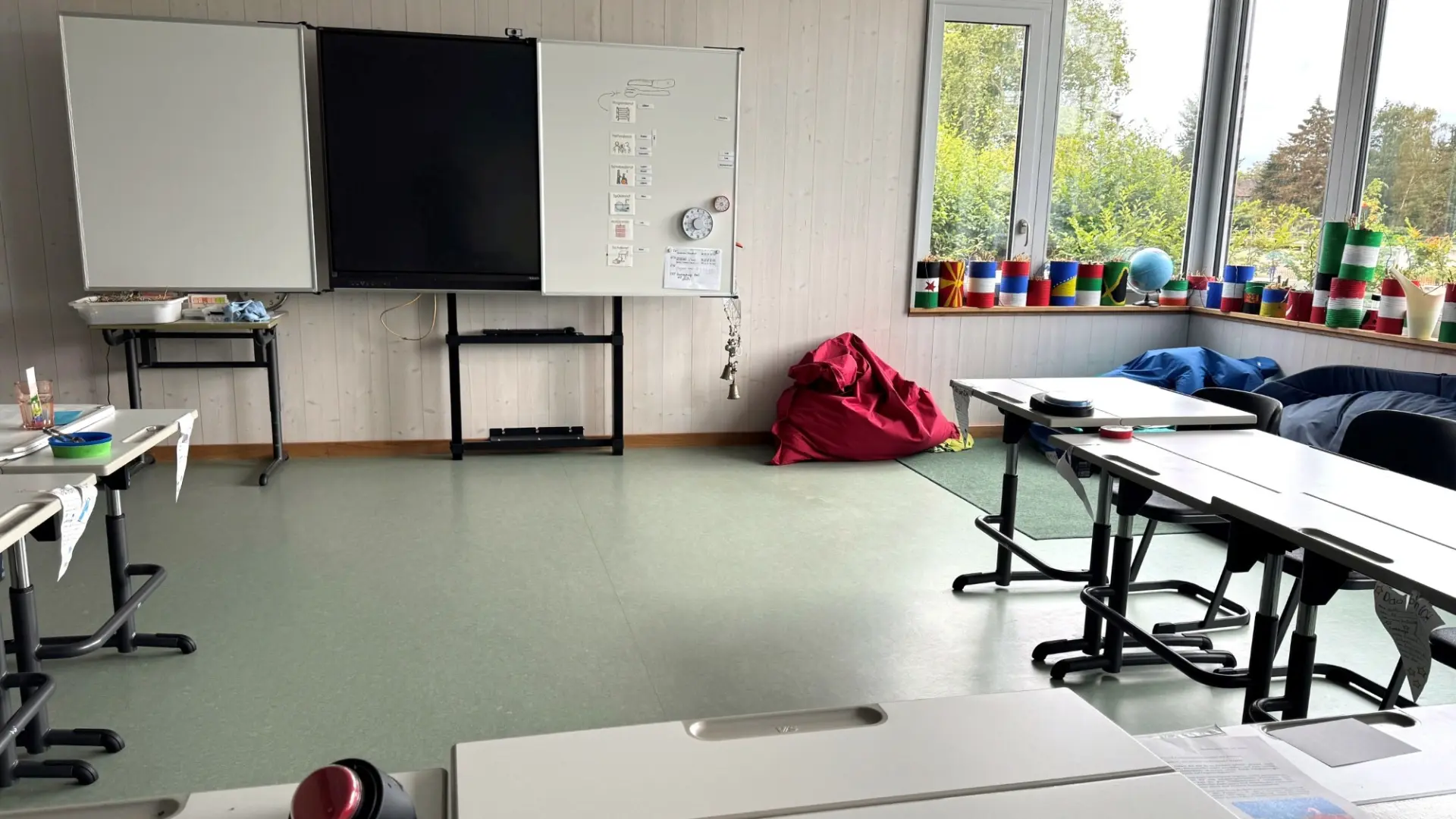 Blick in ein helles Klassenzimmer mit hohen Fenstern