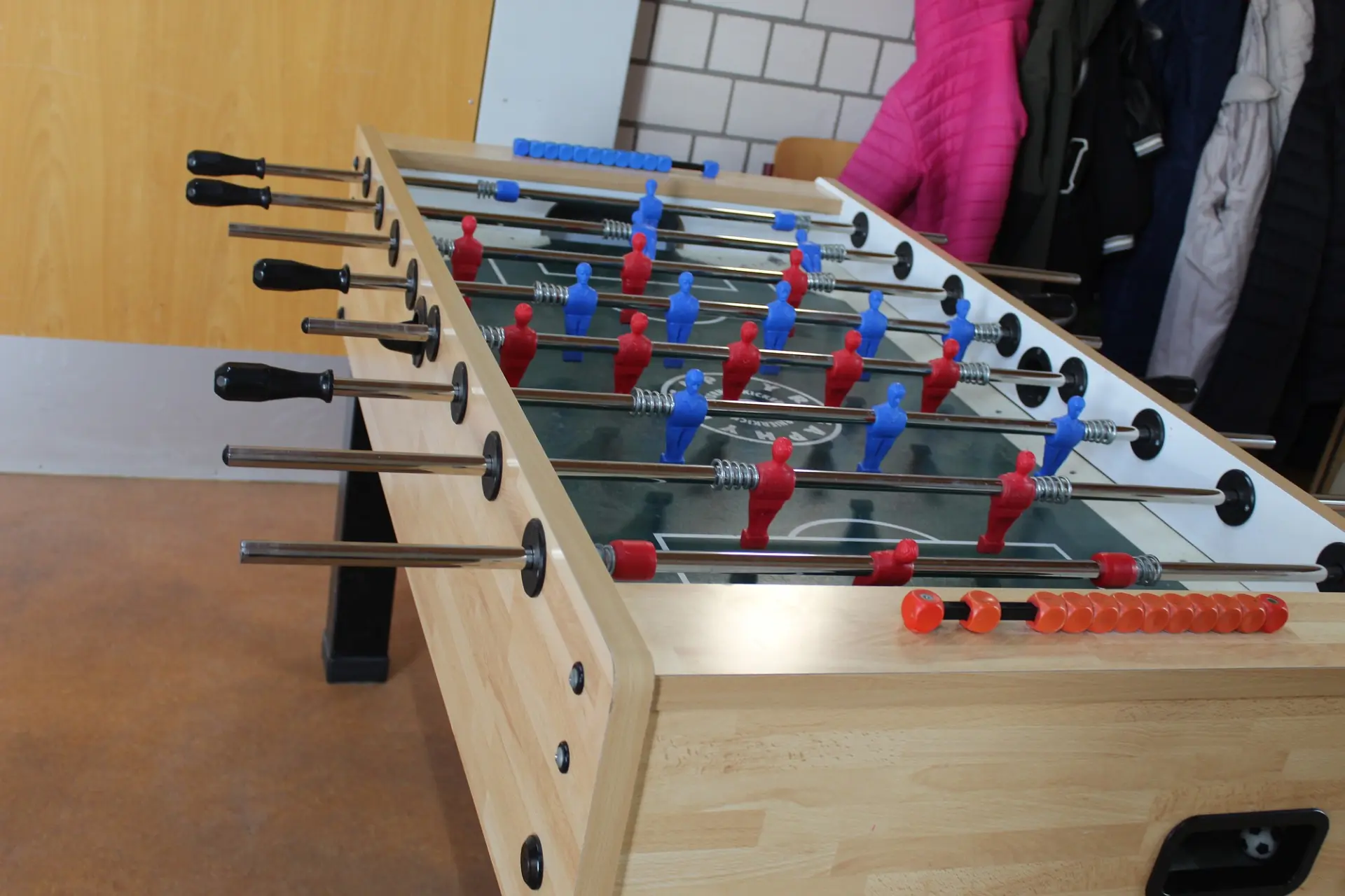 Ein Kickertisch aus hellem Holz im Schulflur