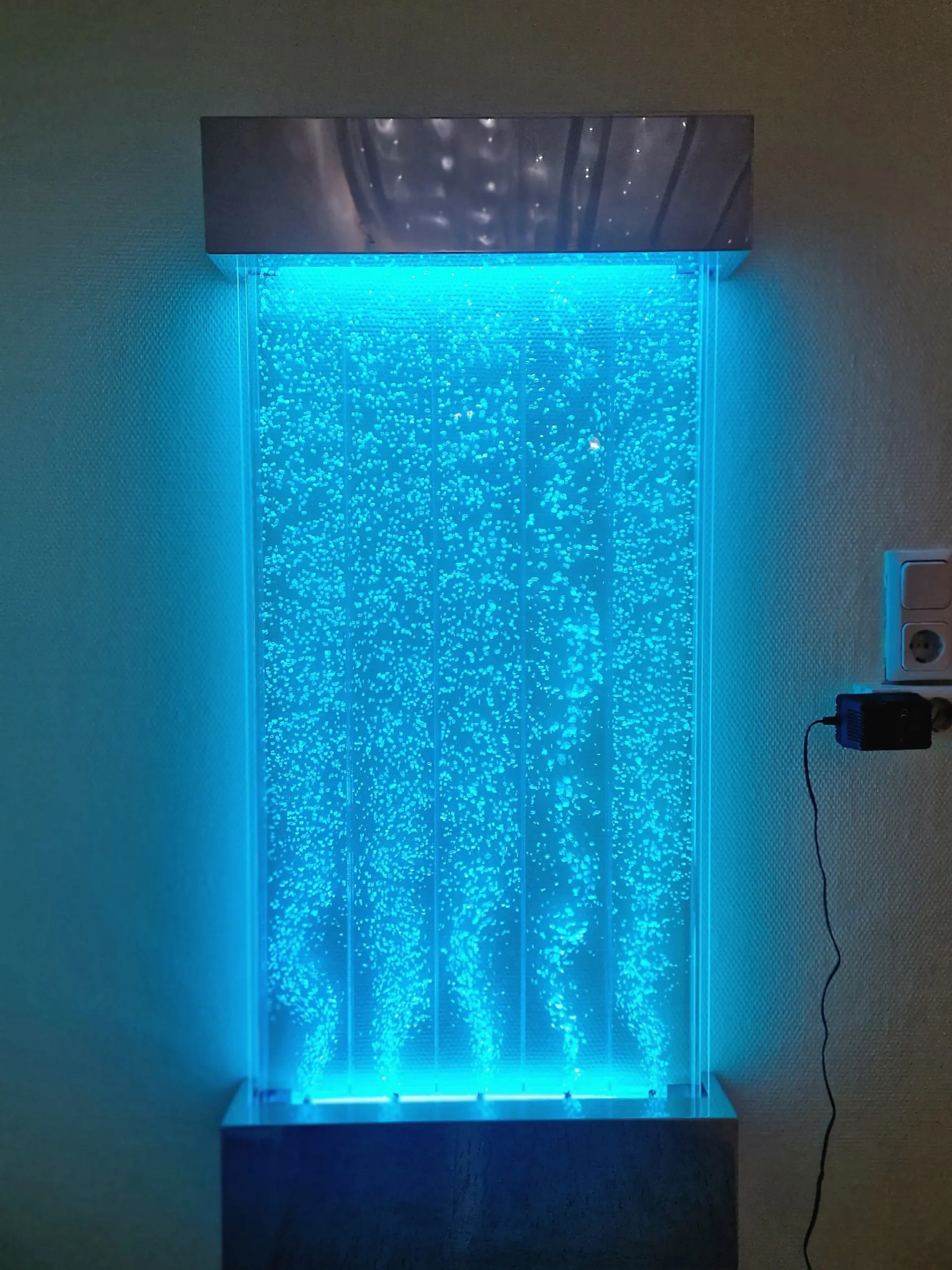 Eine breite, durchsichtige Maschine mit Wasserblasen in ihr, die blau leuchtet.