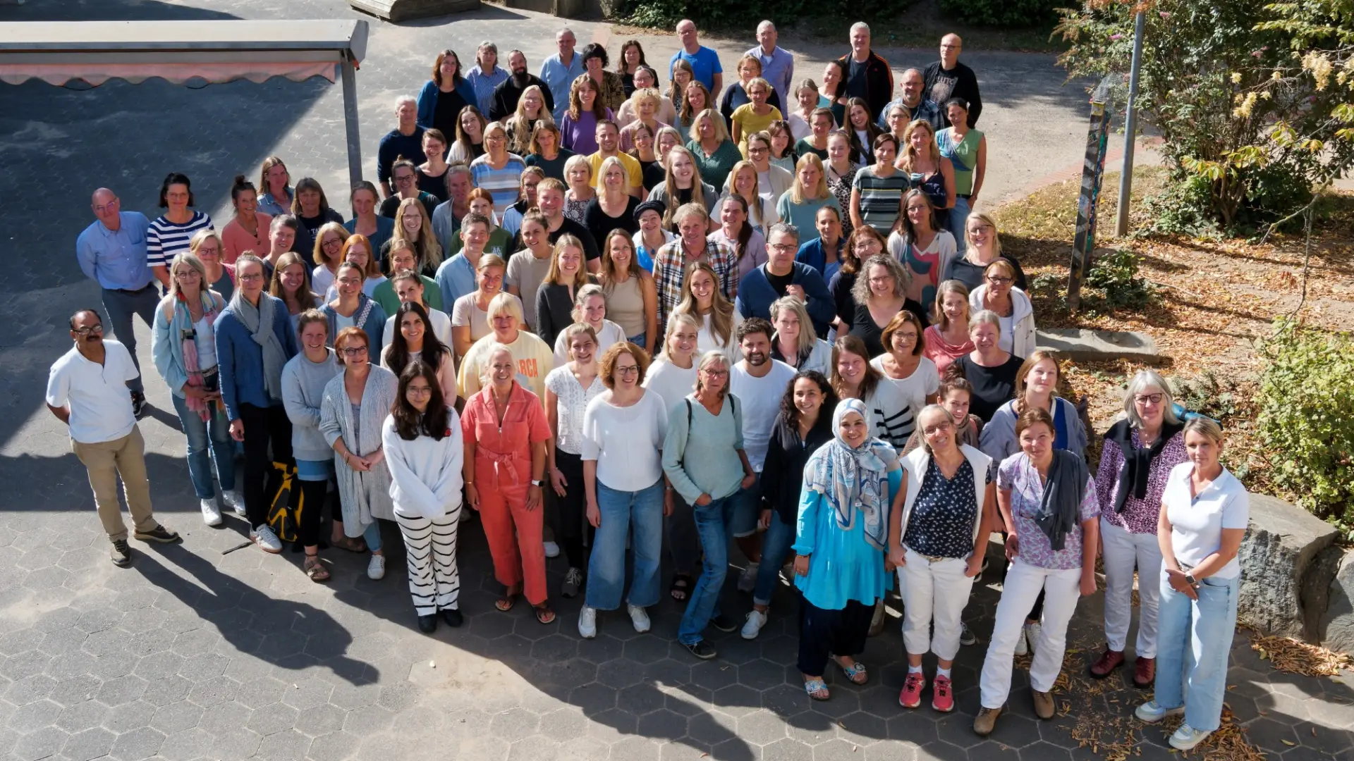Das Gesamtkollegium der Schule im Schulhof und von einem erhöhten Standpunkt fotografiert