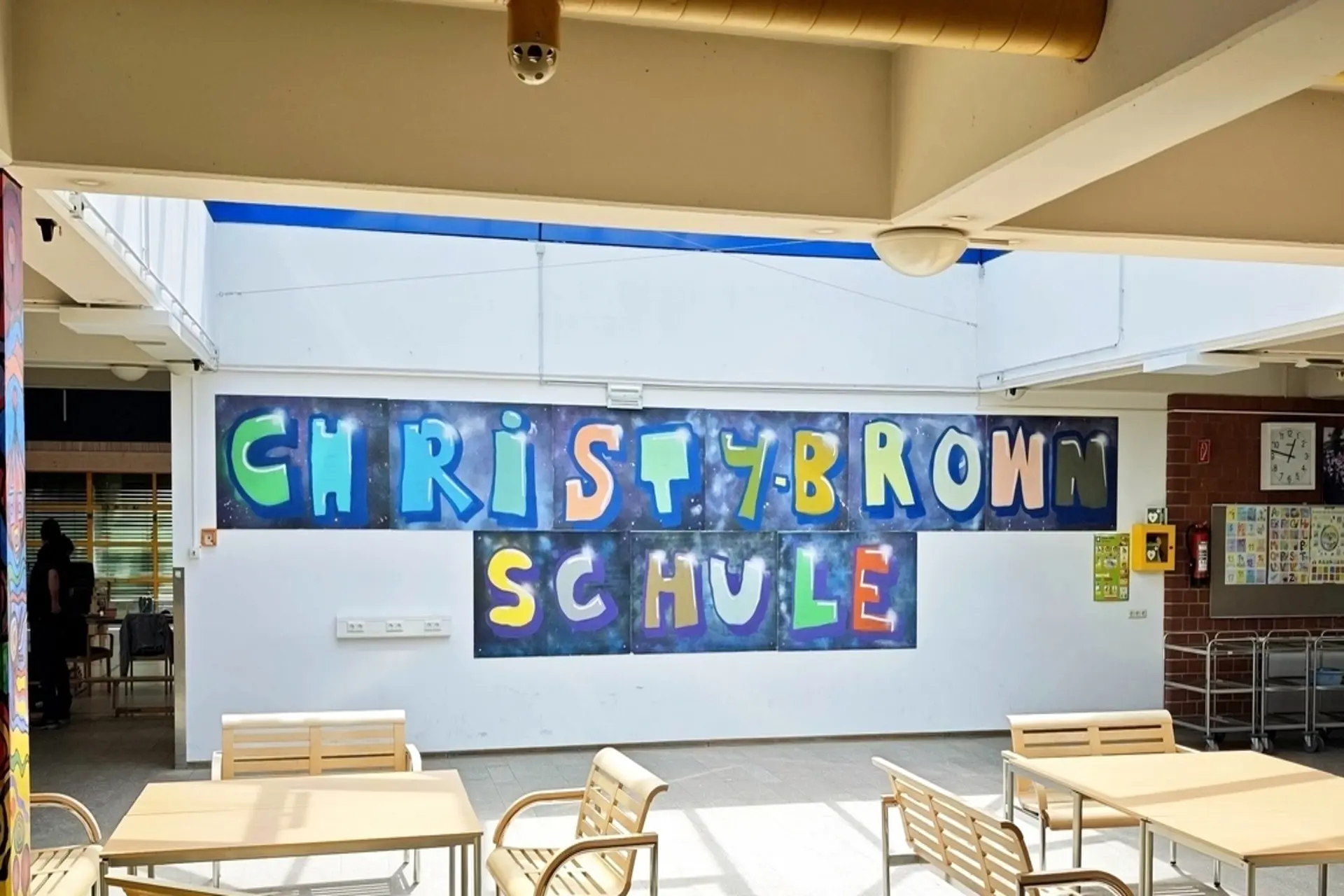 Bunter Schriftzug "Christy-Brown-Schule" auf dem Schulflur.