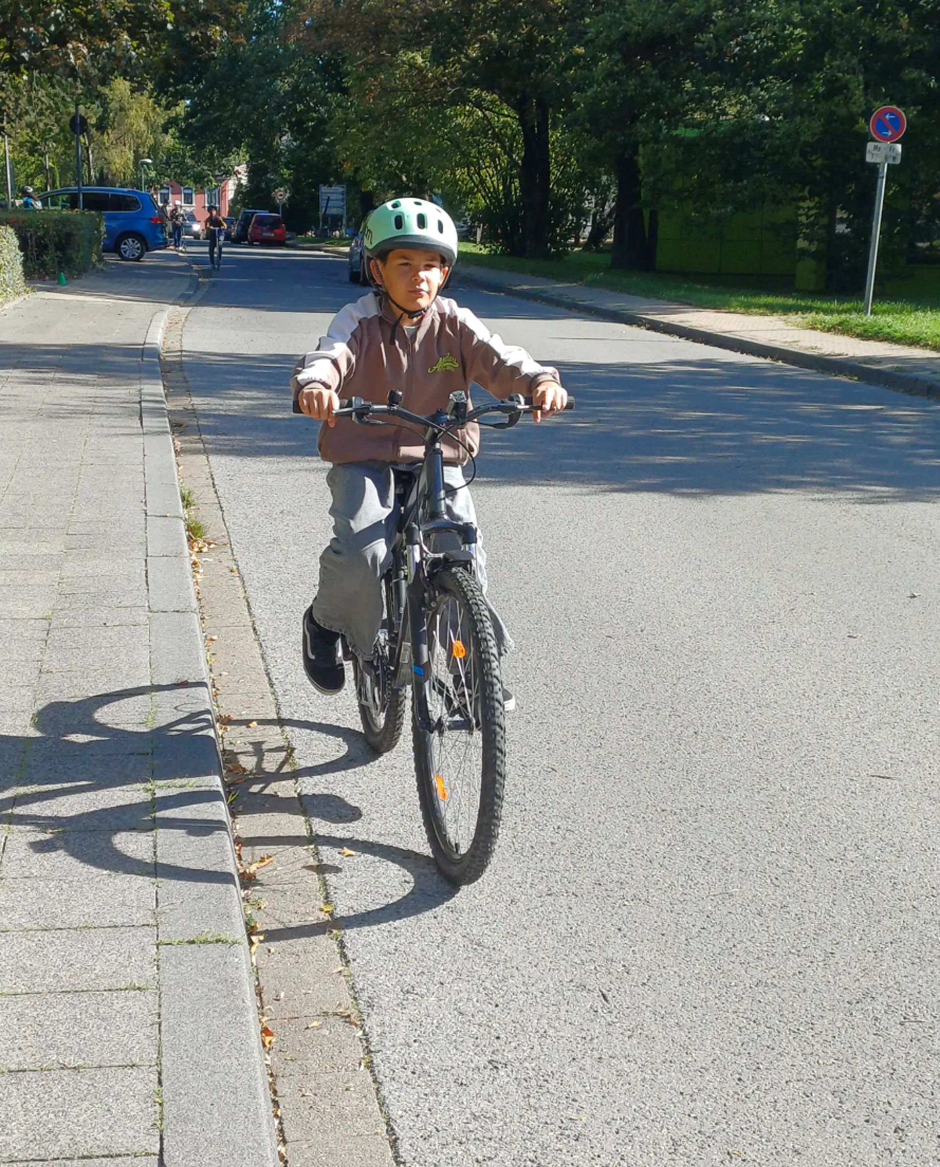 Ein Junge der 4. Klasse fährt mit seinem Fahrrad auf der Straße. 