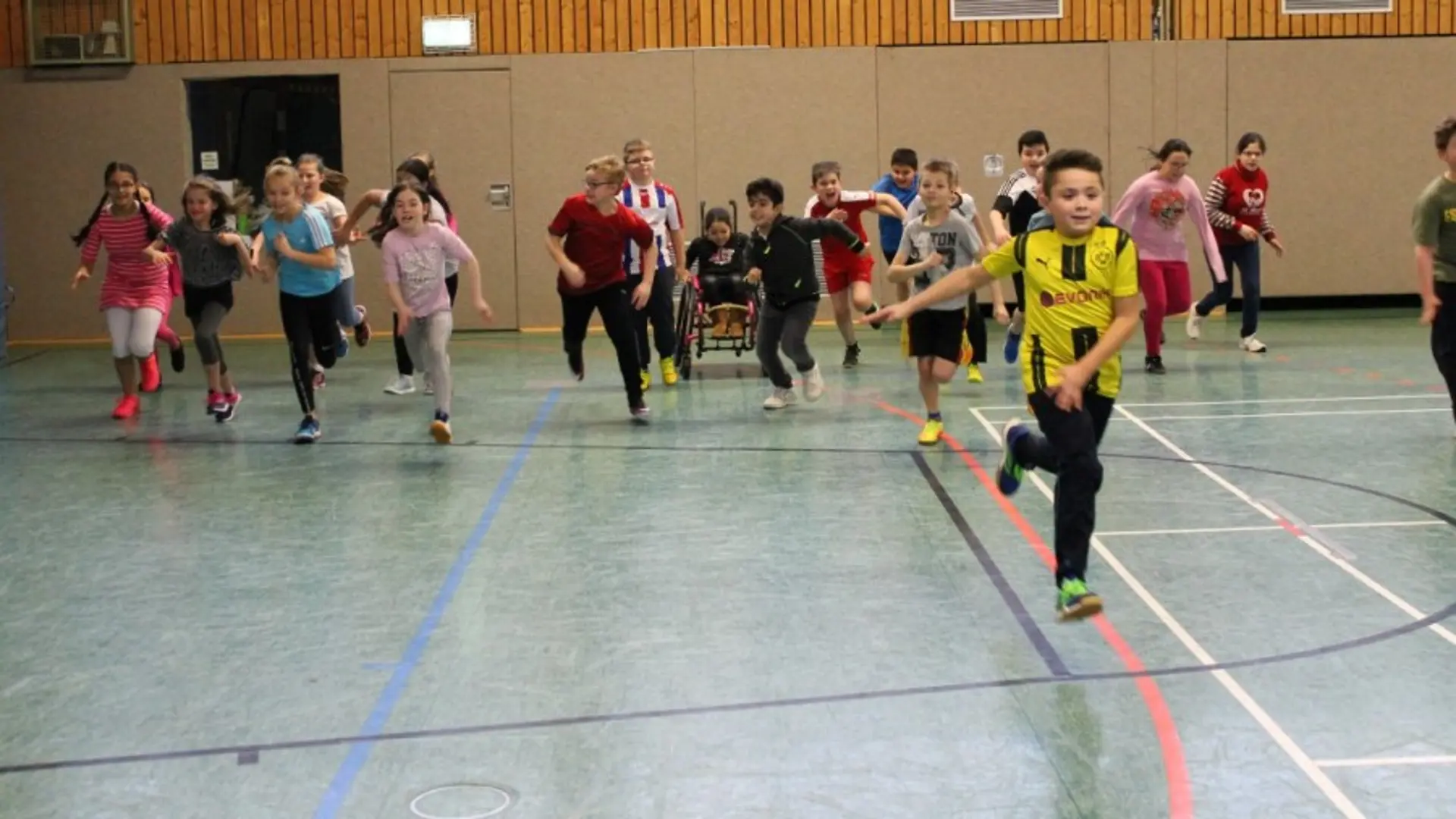 Buntes Gemälde des Maskottchens der Schule: ein fröhliches Flusspferd, dass die Arme in die Luft reckt. Es scheint zu tanzen. Es trägt einen blauen Rock mit Streifen auf dem Fische, ein Boot nd eine Schildkröte zu sehen sind.
