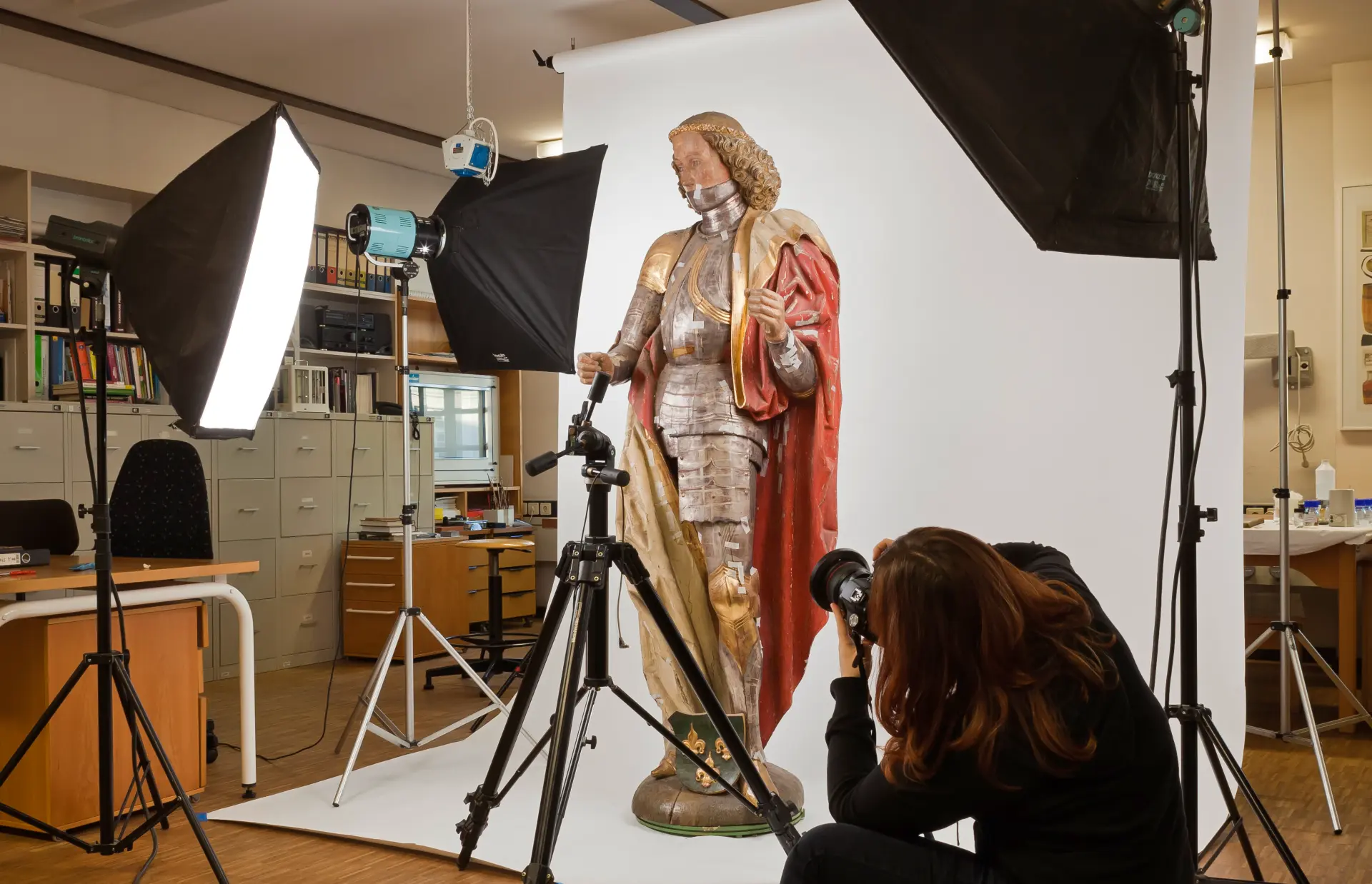 Fotografin im Atelier bei der Arbeit, Skulptur ausleuchten und fotografieren.