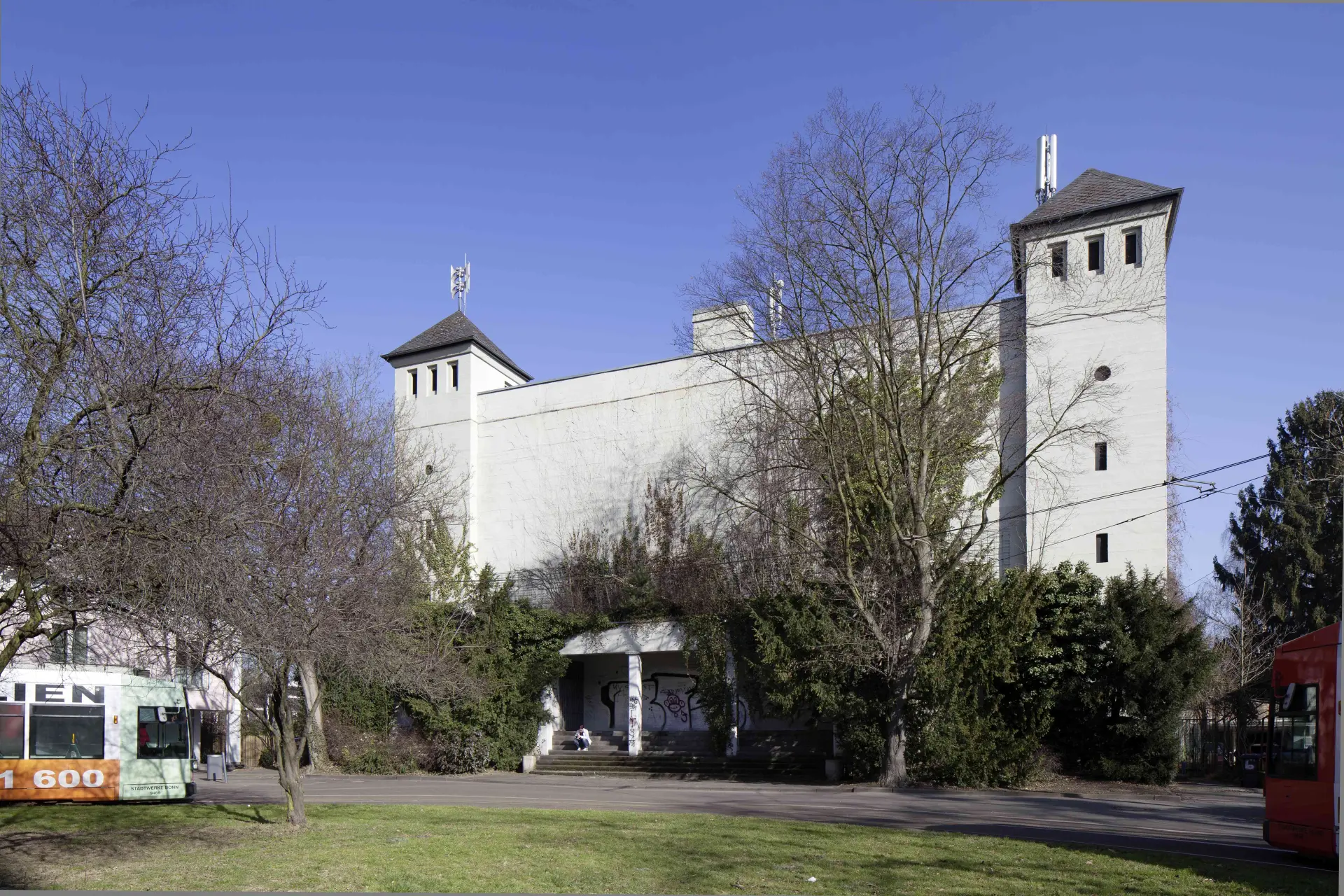 Innerstädtisch gelegener, weiß geschlämmter Hochbunker mit seitlich vorgelagerten Türmen aus der Zeit des Nationalsozialismus mit vorgelagerter, begrünter Platzanlage. 