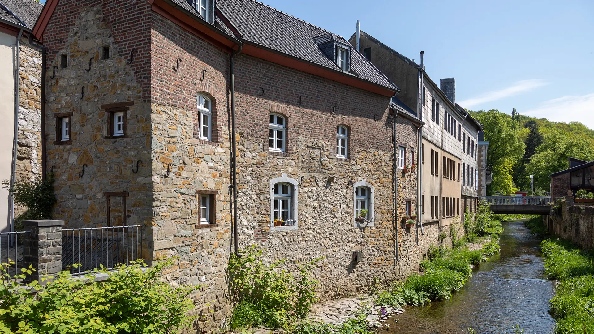 historische Wohnhäuser, die an einen Bach angrenzen