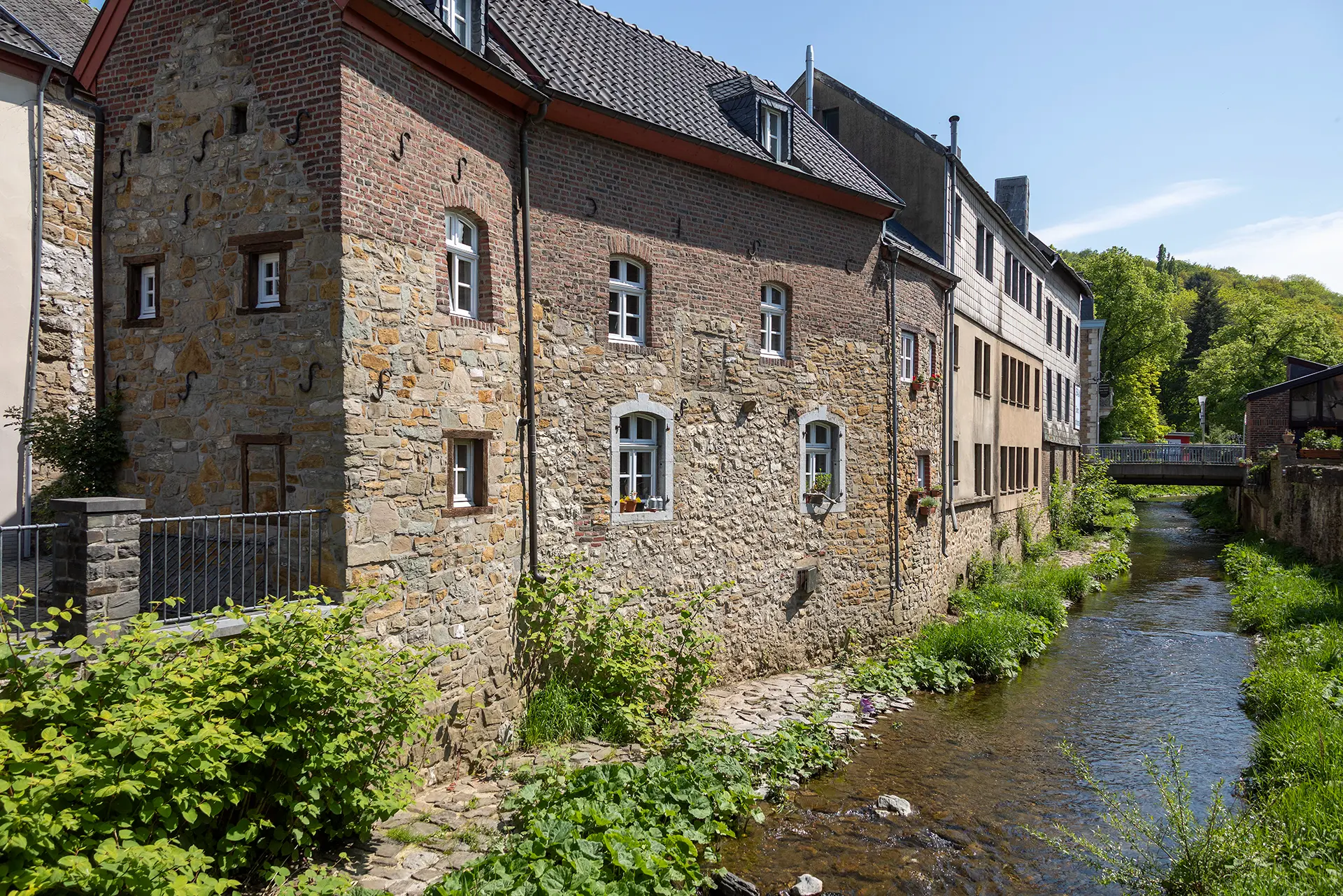 historische Wohnhäuser, die an einen Bach angrenzen