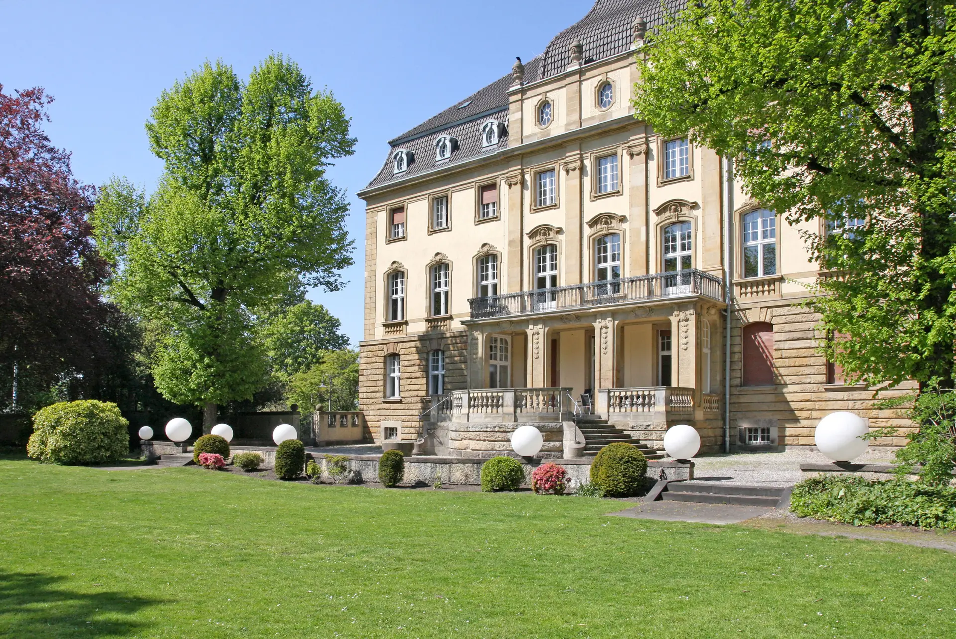 mehrstöckiges repräsentatives Gebäude mit Parkanlage