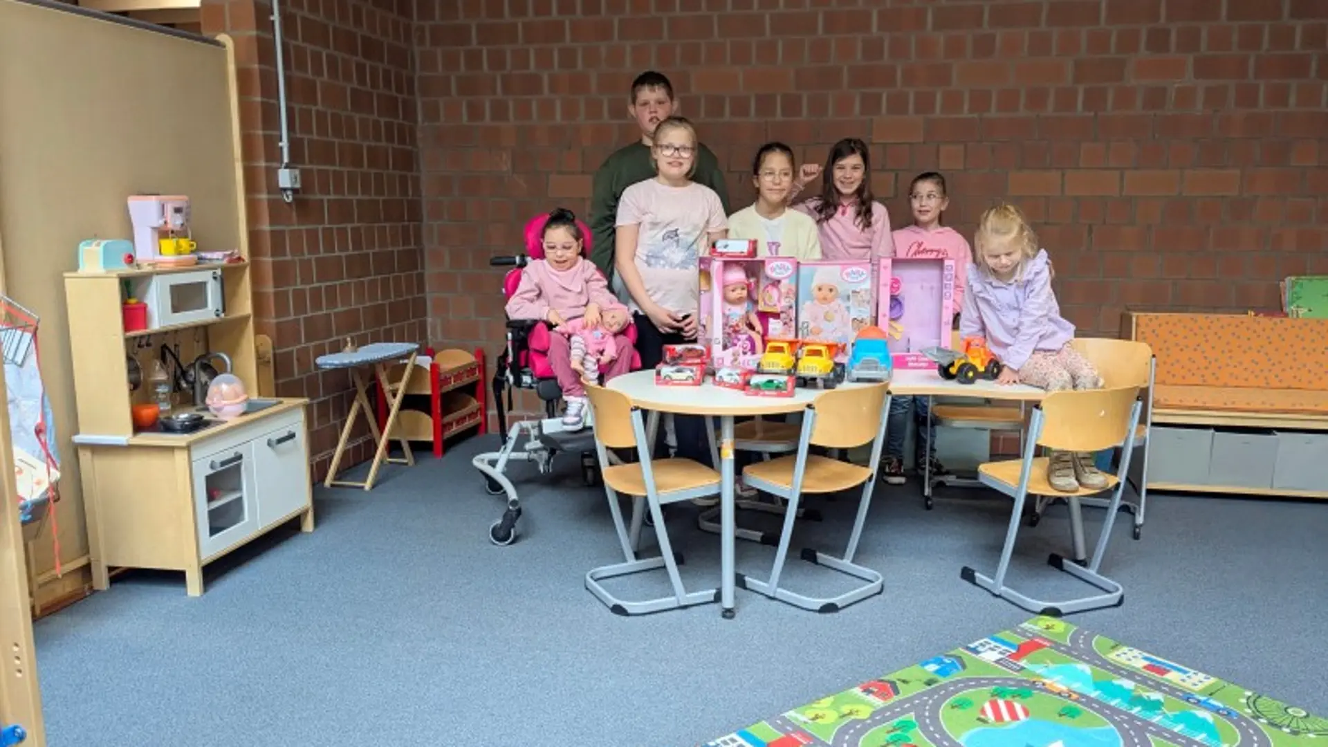 Eine Gruppe Schüler*innen steht hinter einem Tisch mit neuen Spielsachen