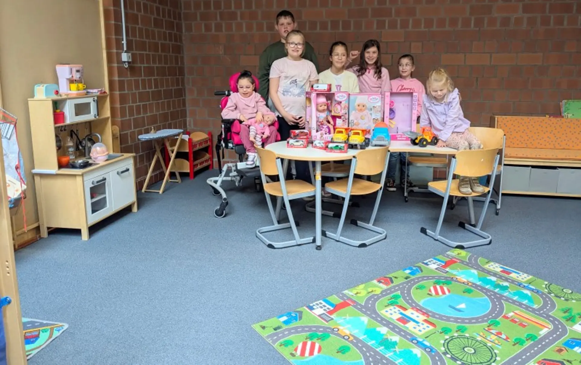 Eine Gruppe Schüler*innen steht hinter einem Tisch mit neuen Spielsachen