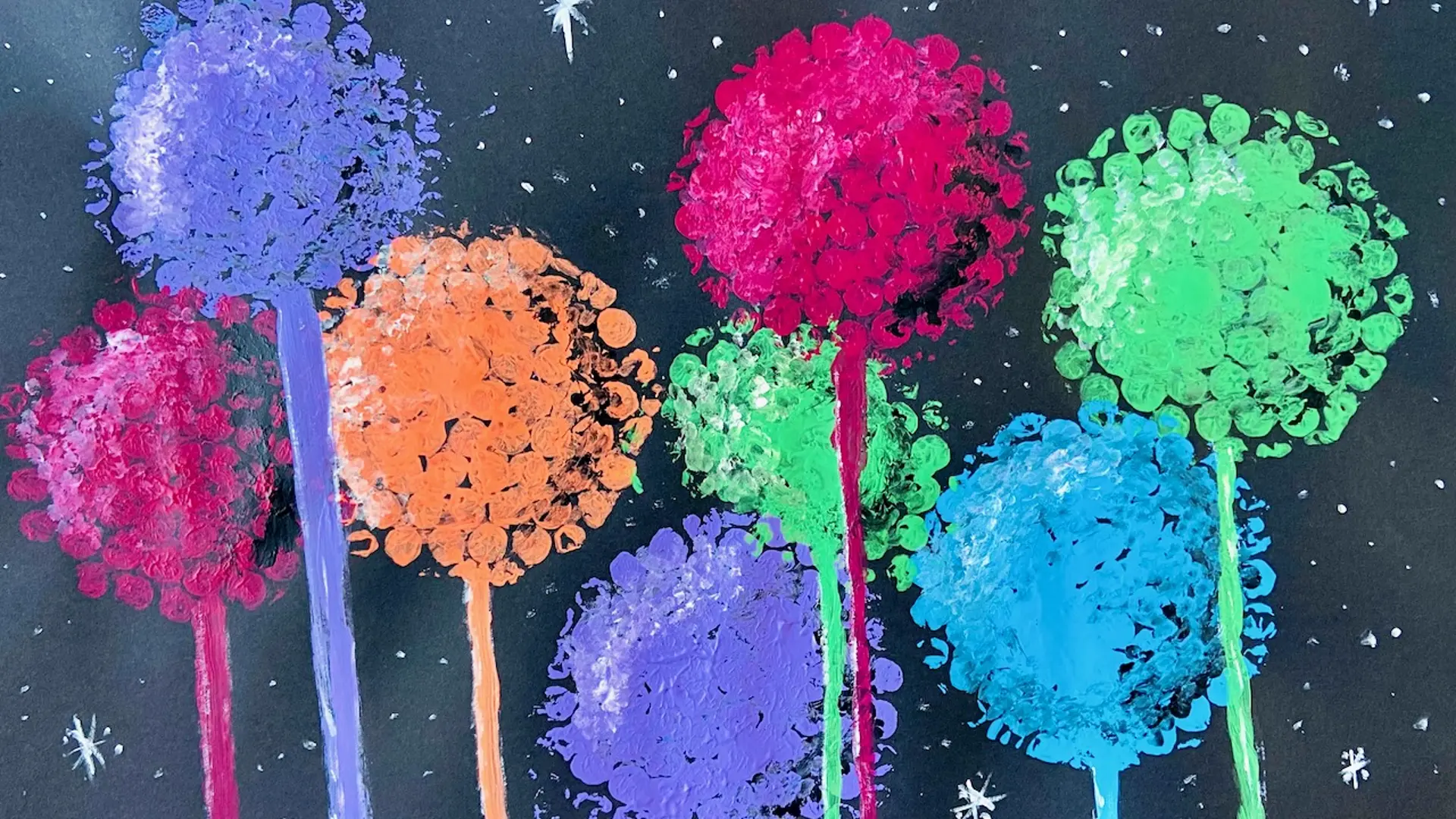 Ein Bild mit bunten Pusteblumen, die mit Plakafarbe auf Schwarzes Papier gemalt und gestempelt wurden.