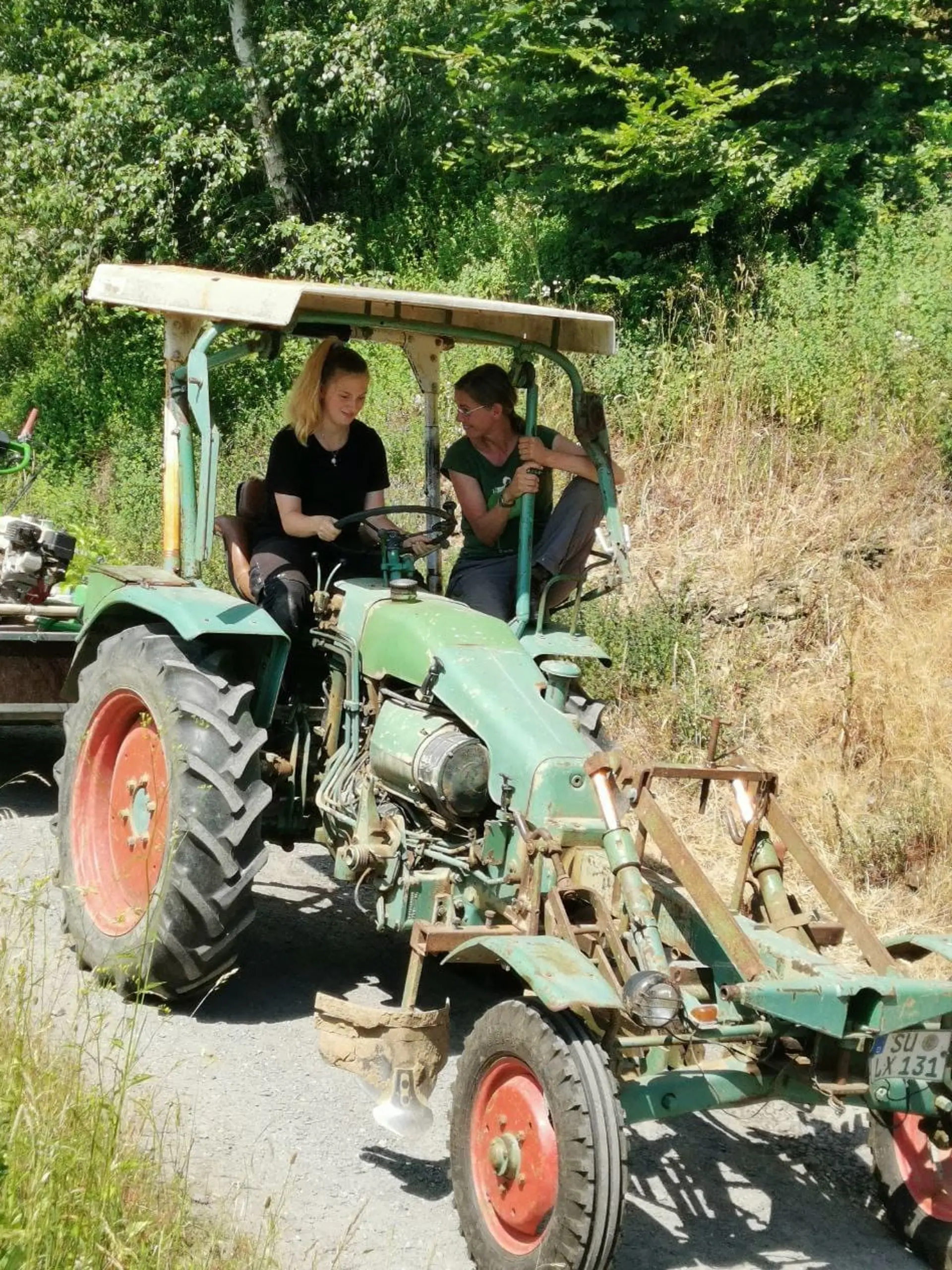 Zwei Freiwillige fahren Traktor.