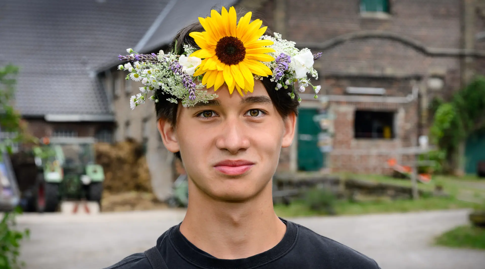 Ein Freiwilliger mit Blumenkranz im FÖJ-Seminar.